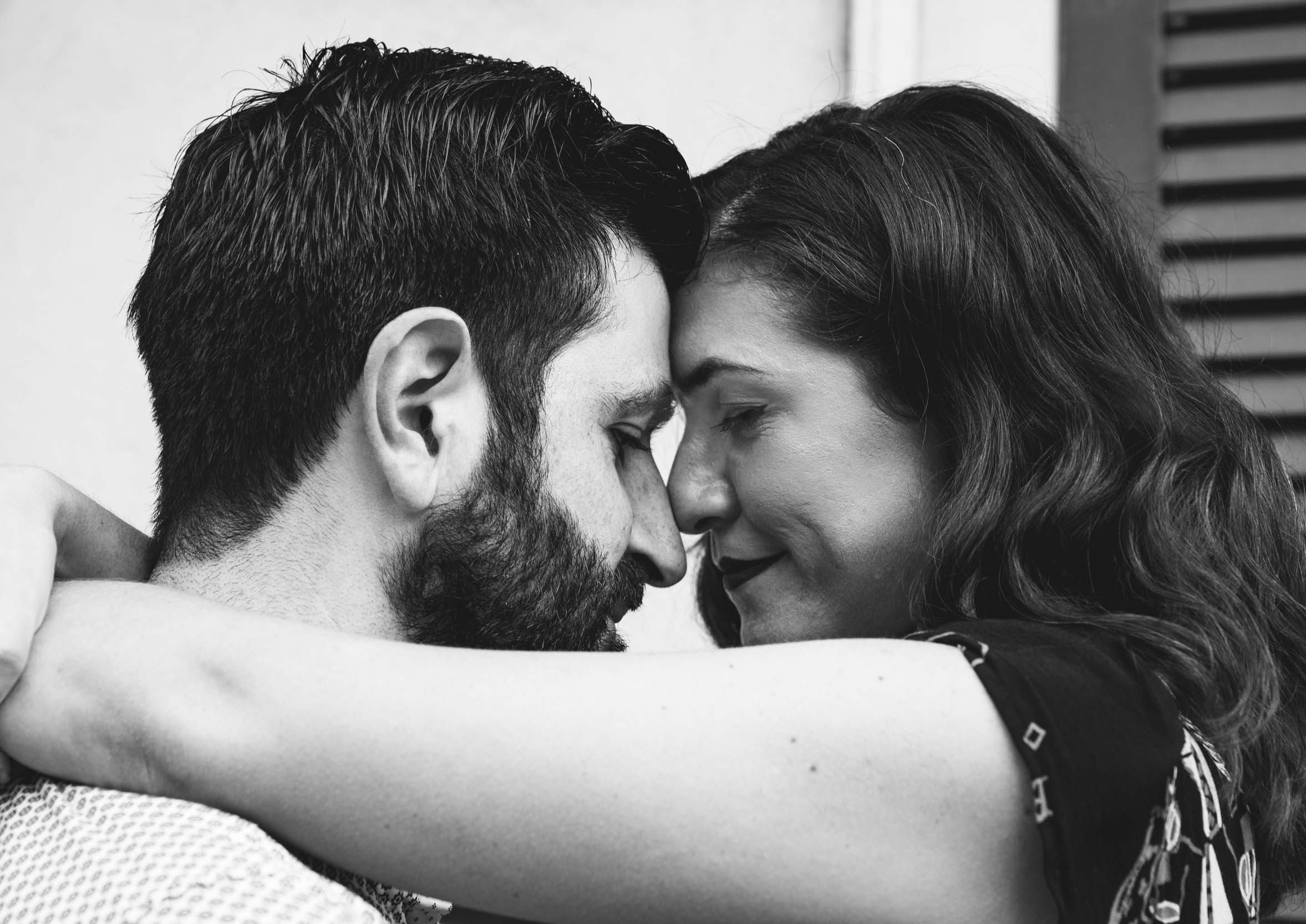 Romantic couple nestling closely together and smiling in the New Orleans French Quarter