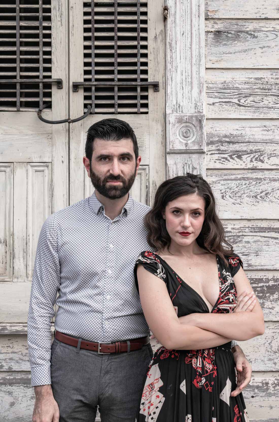 Timid facial expressions of romantic couple in front of rustic house in the New Orleans French Quarter