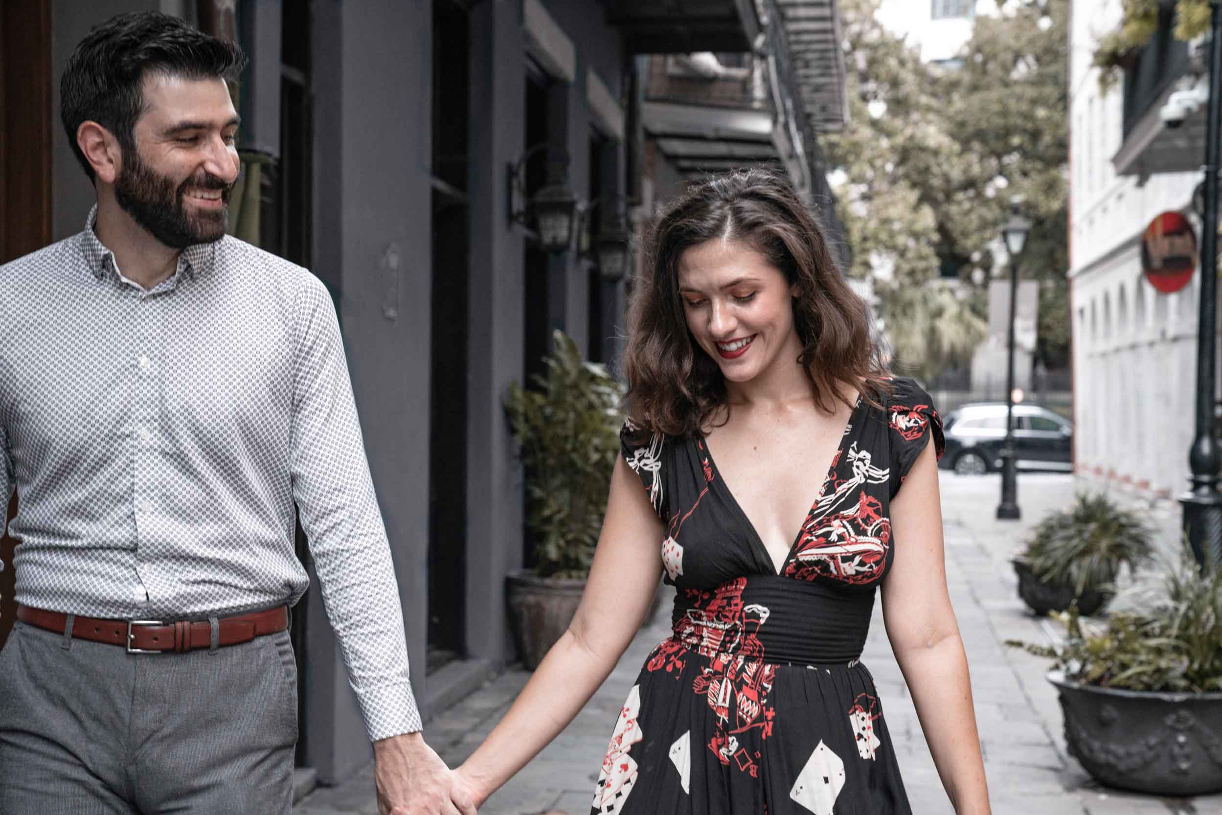 Romantic couple smiling and holding hands in alleyway in the New Orleans French Quarter