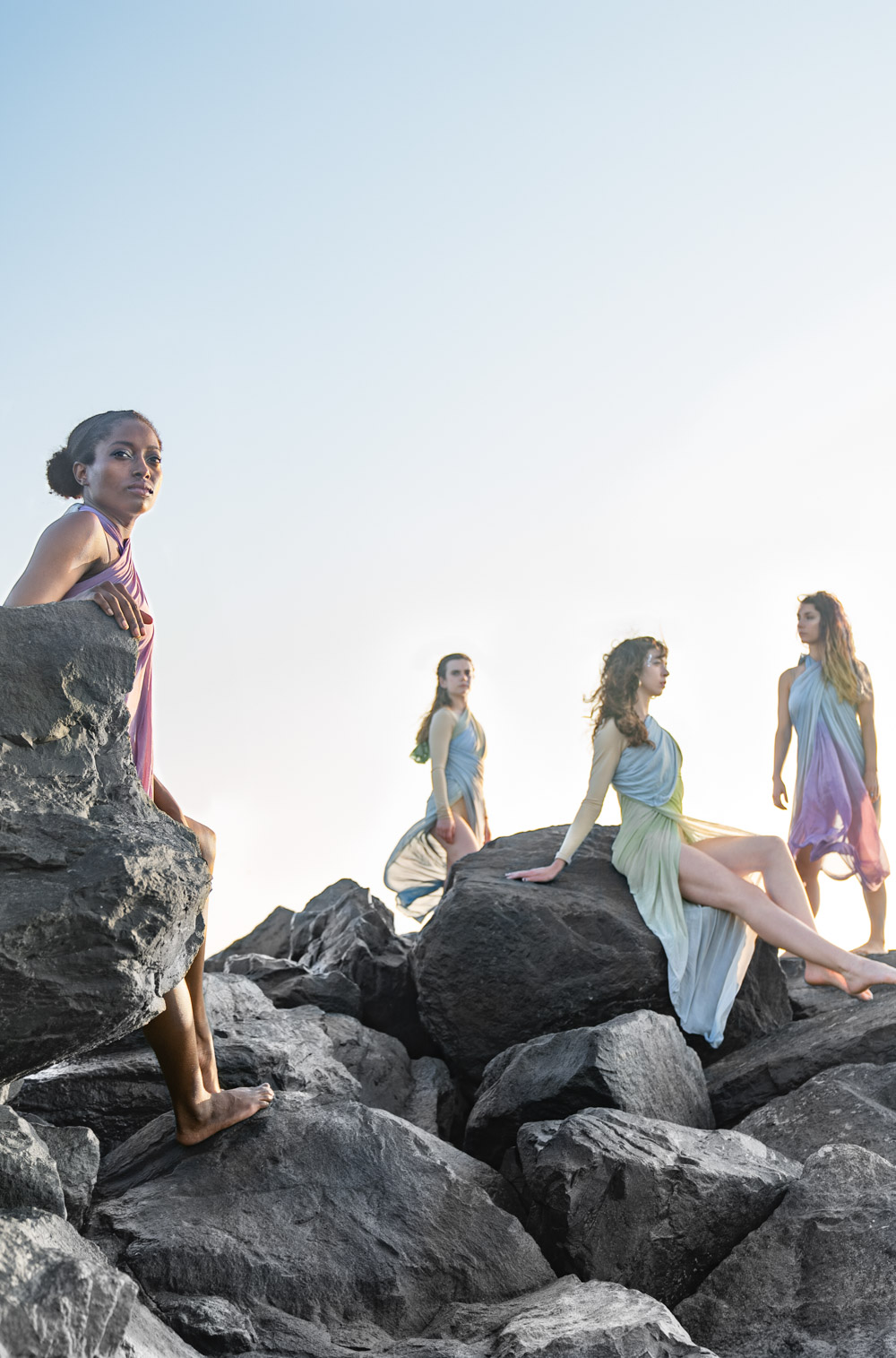 Women posing like mermaids on the beach at sunset along Louisiana Gulf Coast