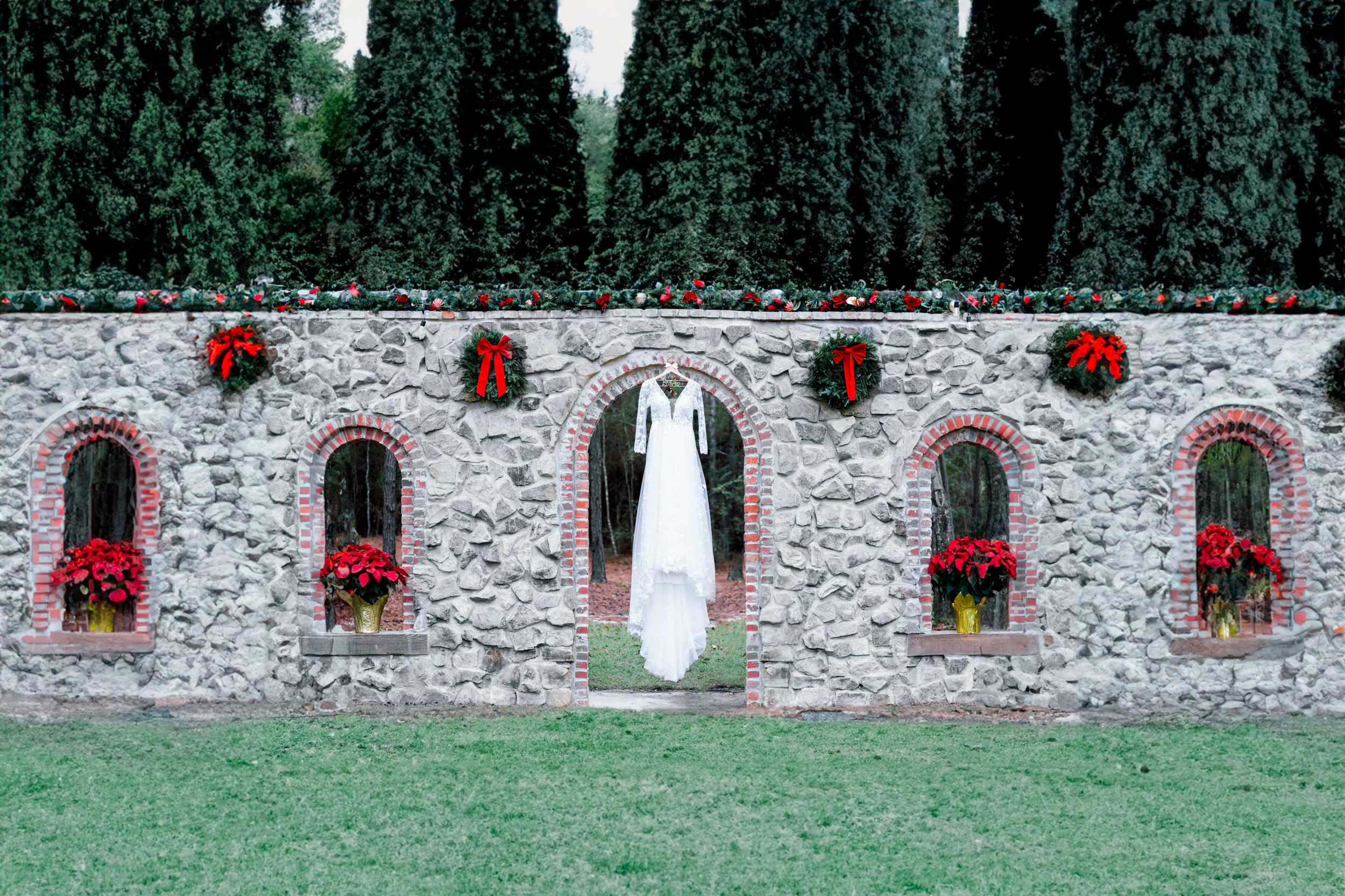 brides dress hanging over stone wall at Creekview Barn in Mississippi