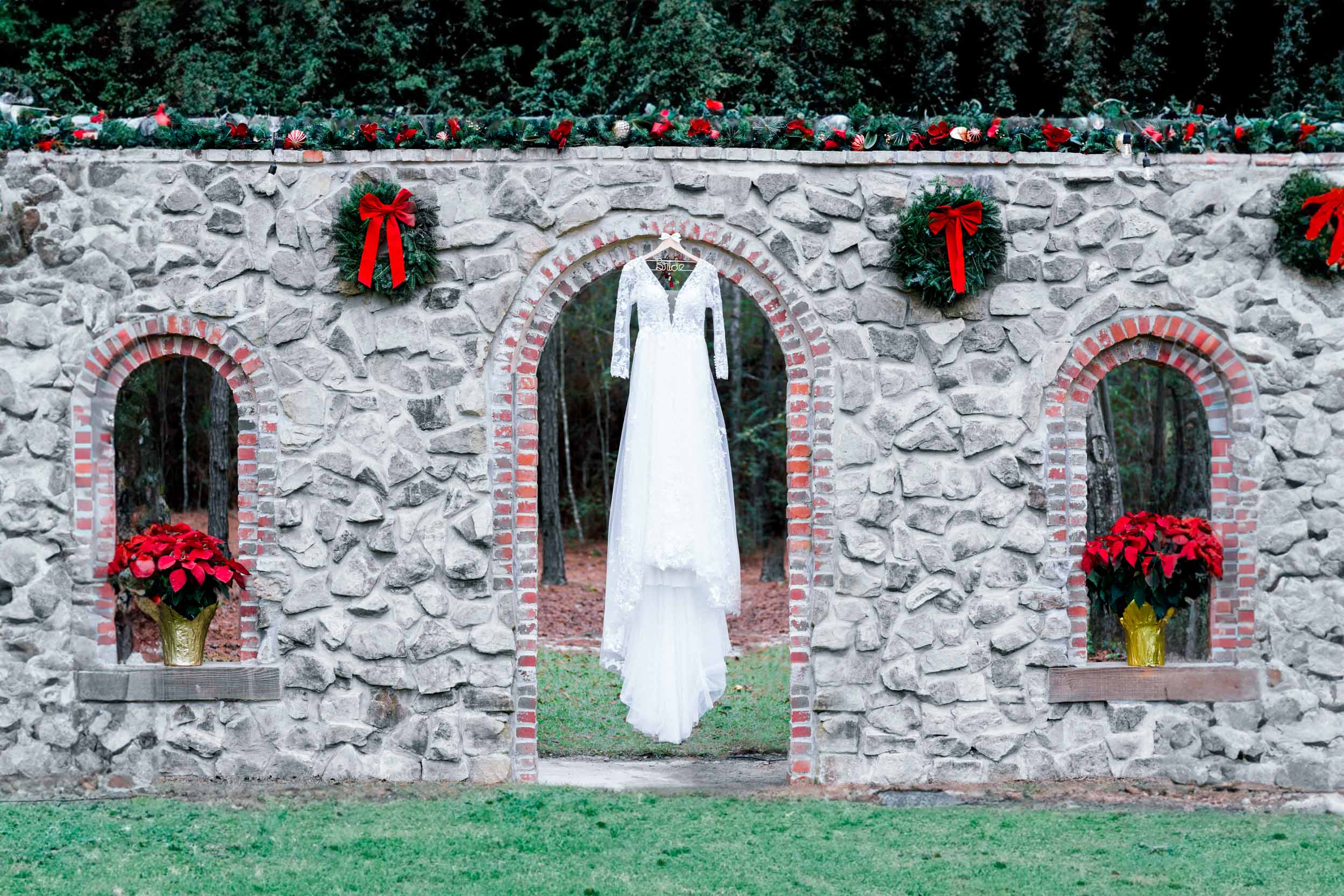 brides dress hanging over stone wall at Creekview Barn in Mississippi