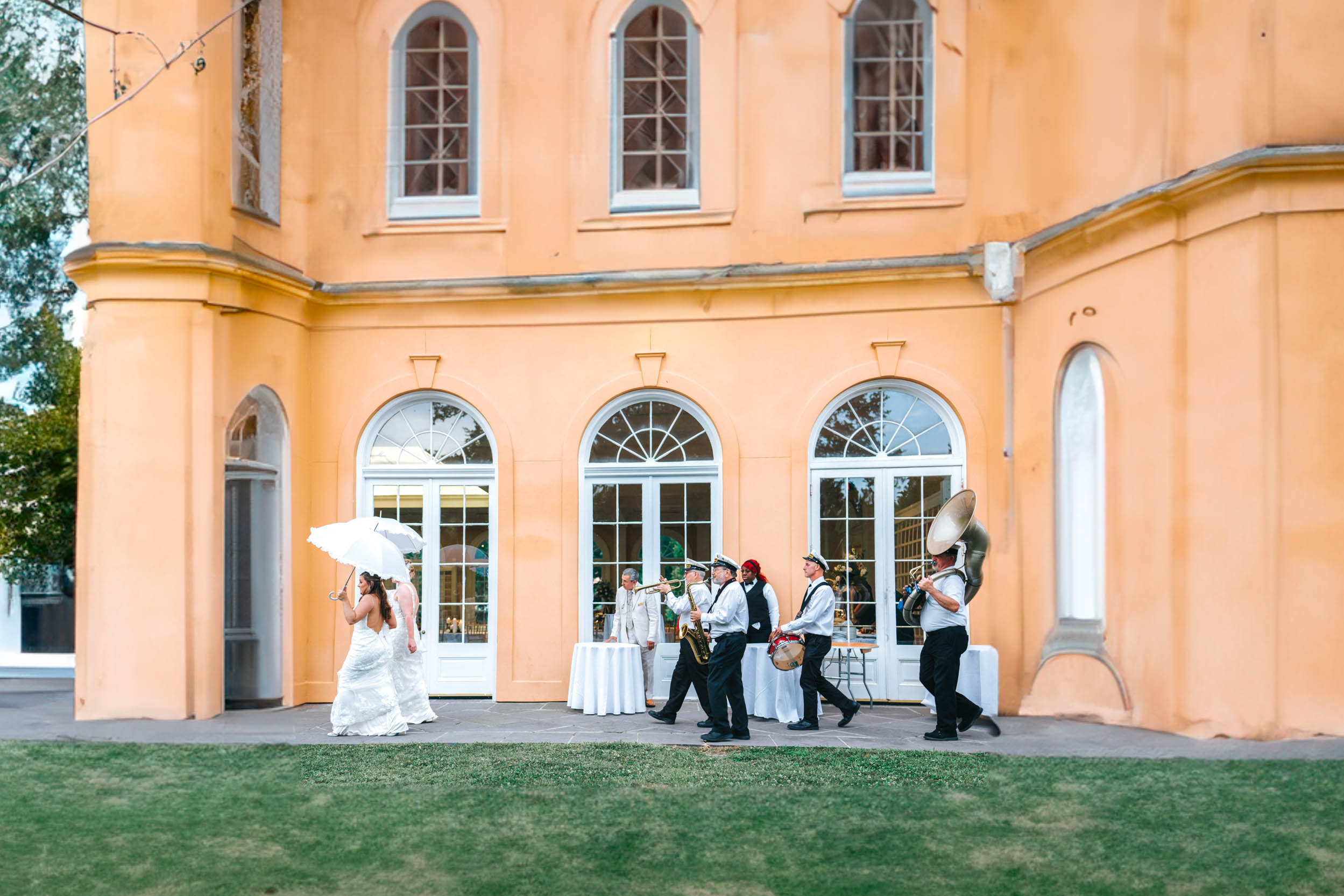 Brass band and wedding guests marching into the Pavillion of Two Sisters in New Orleans
