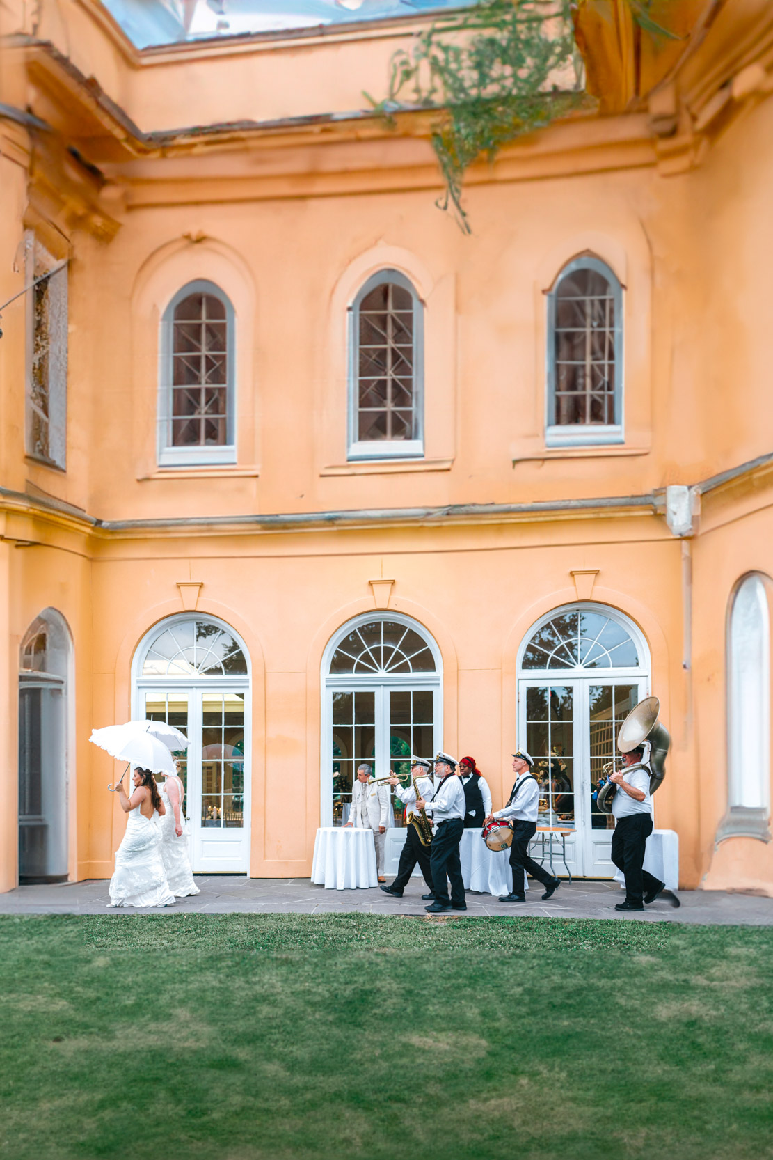 Brass band and wedding guests marching into the Pavillion of Two Sisters in New Orleans