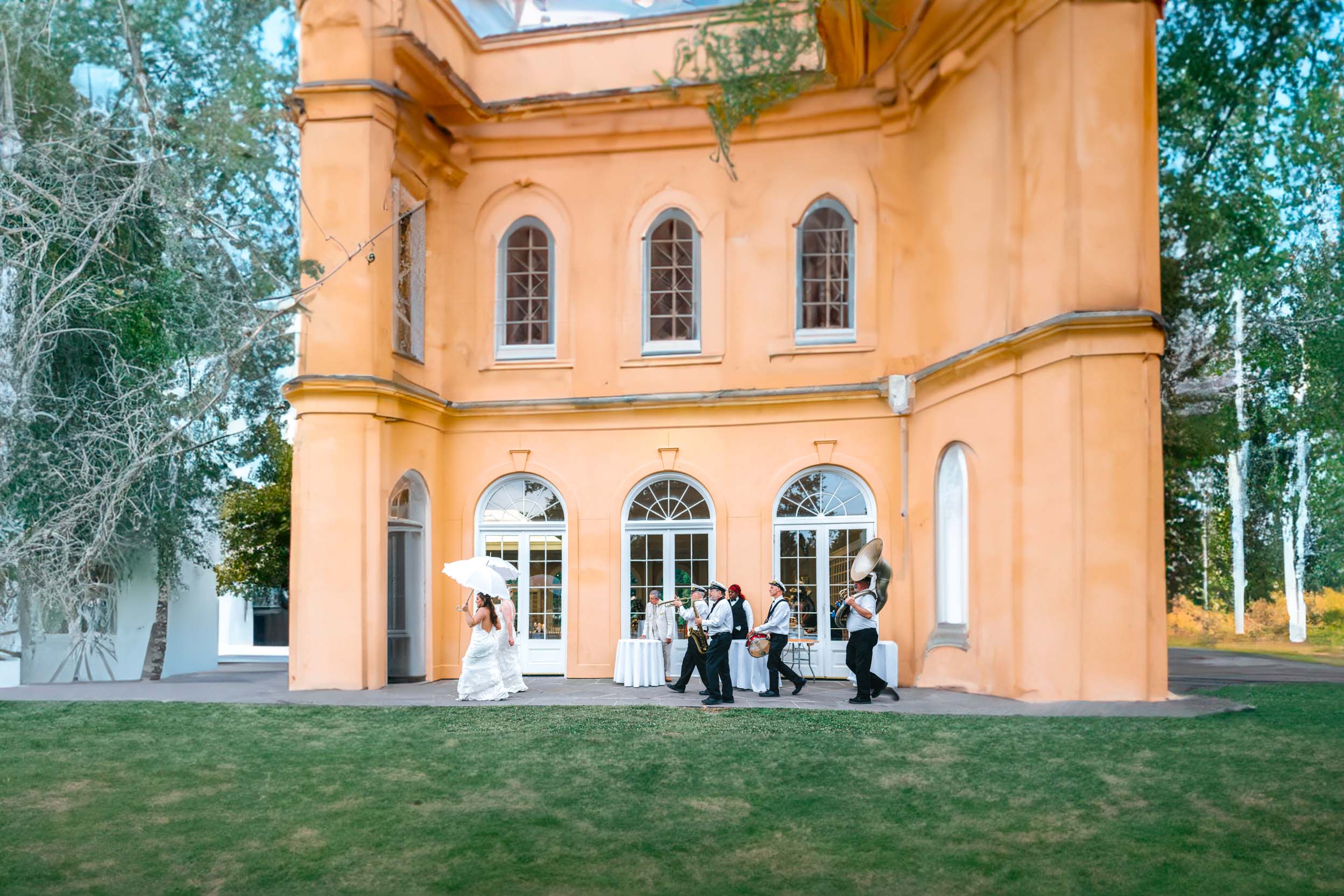 Brass band and wedding guests marching into the Pavillion of Two Sisters in New Orleans