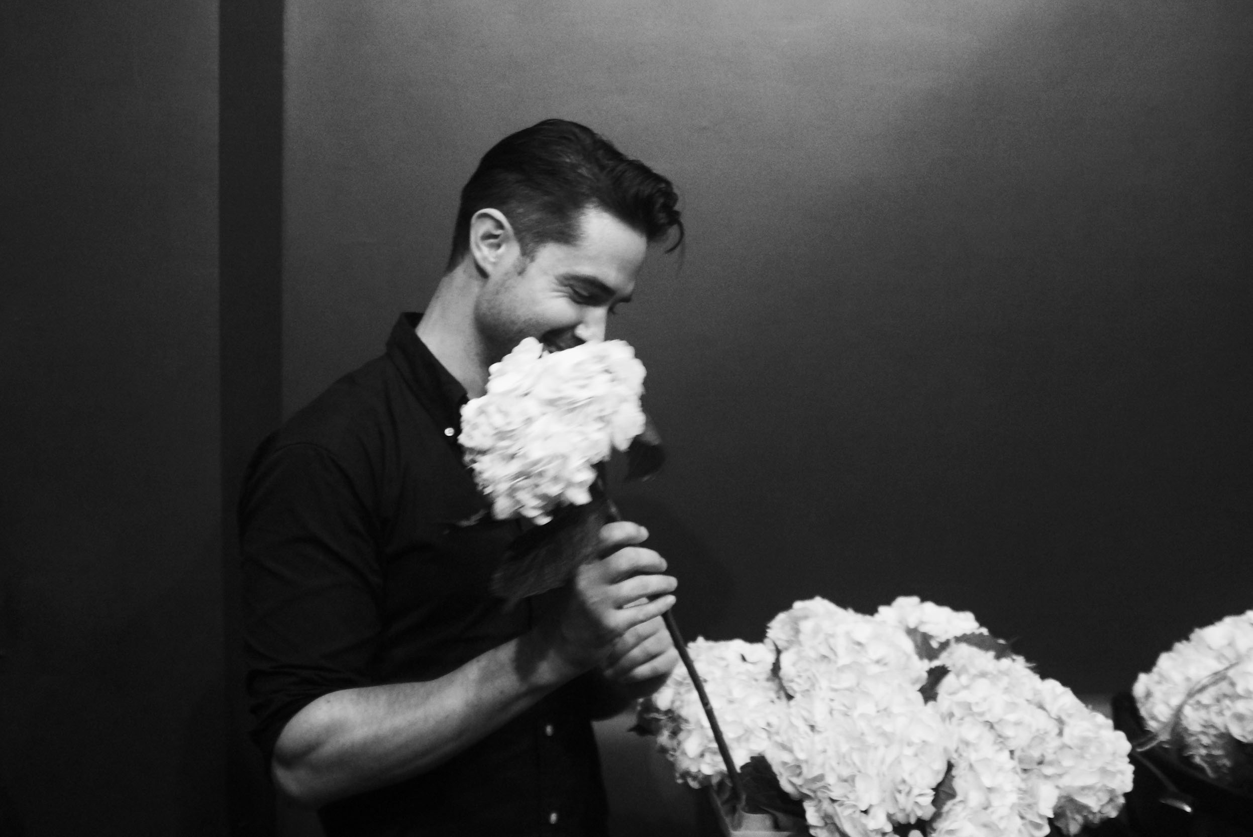 Ryan H Gray with Shades of Gray Photography holding flowers and smiling before shooting a wedding in New Orleans