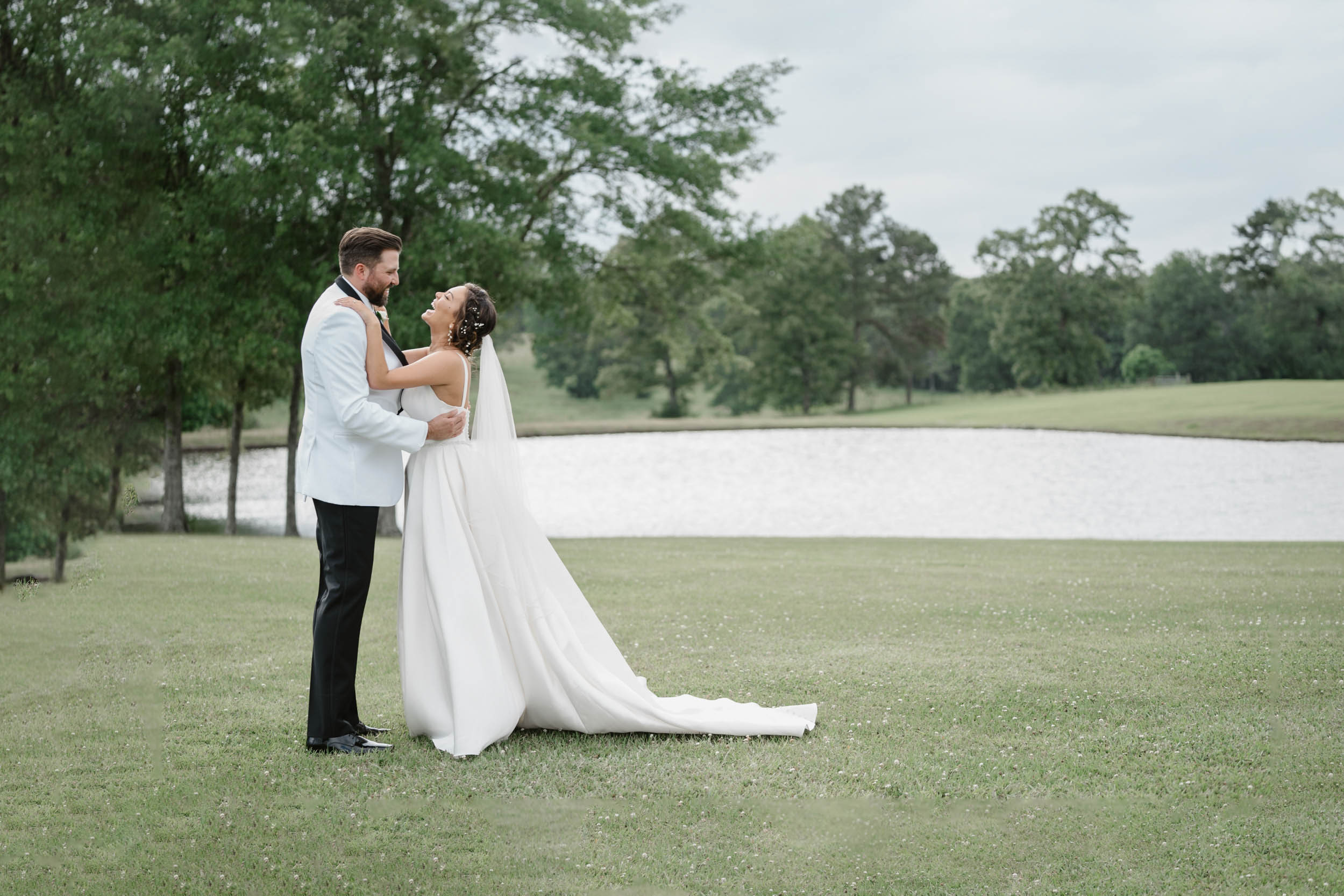 bride and groom laughing in a field at White Magnolia in Lousiana