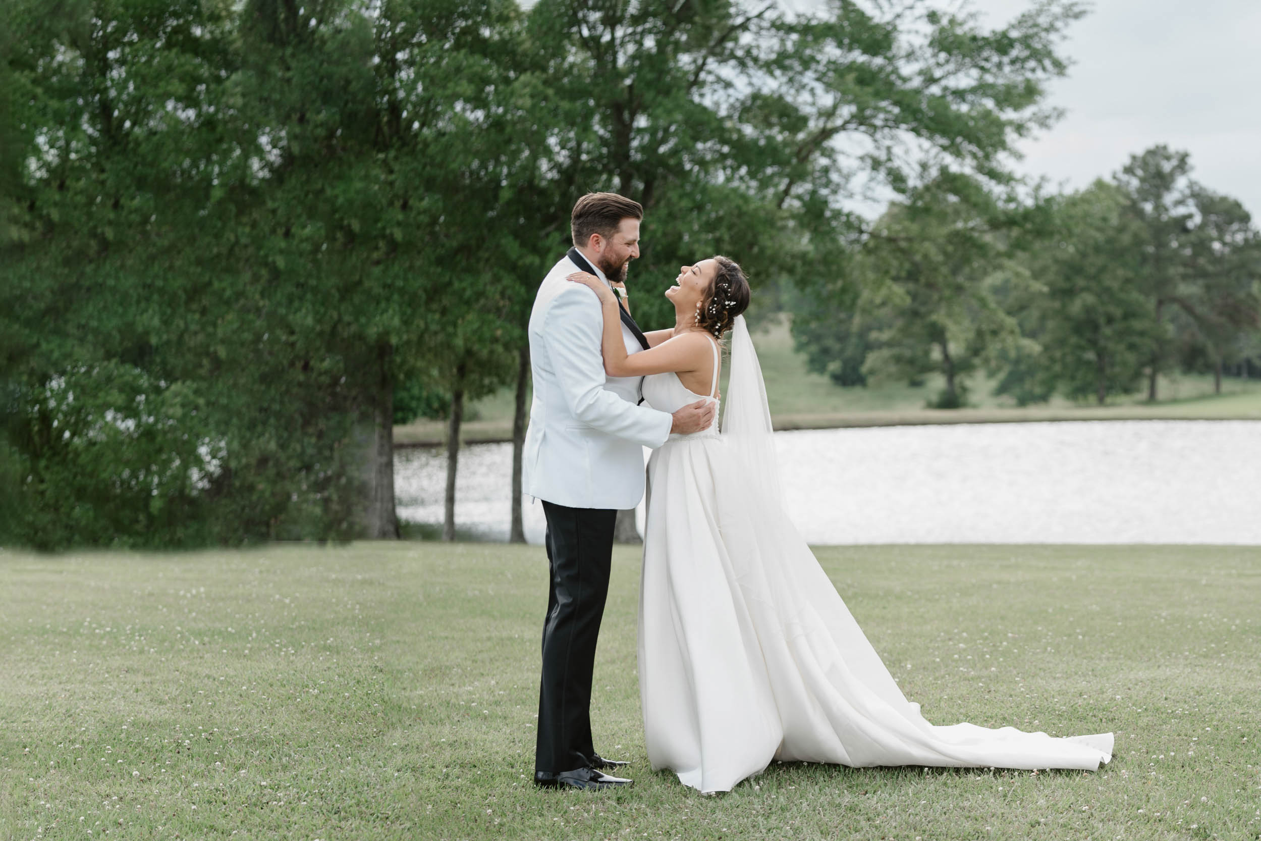bride and groom laughing in a field at White Magnolia in Lousiana