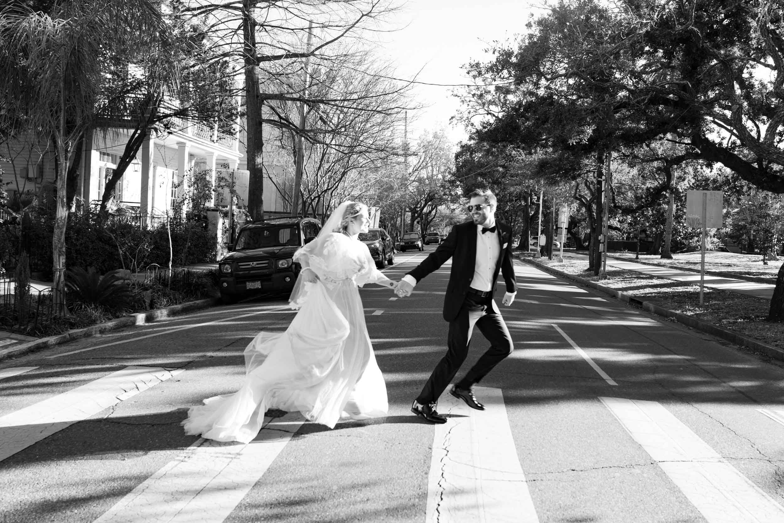 bride and groom running across street in New Orleans on wedding day, inspired by The Beatles Abbey Road