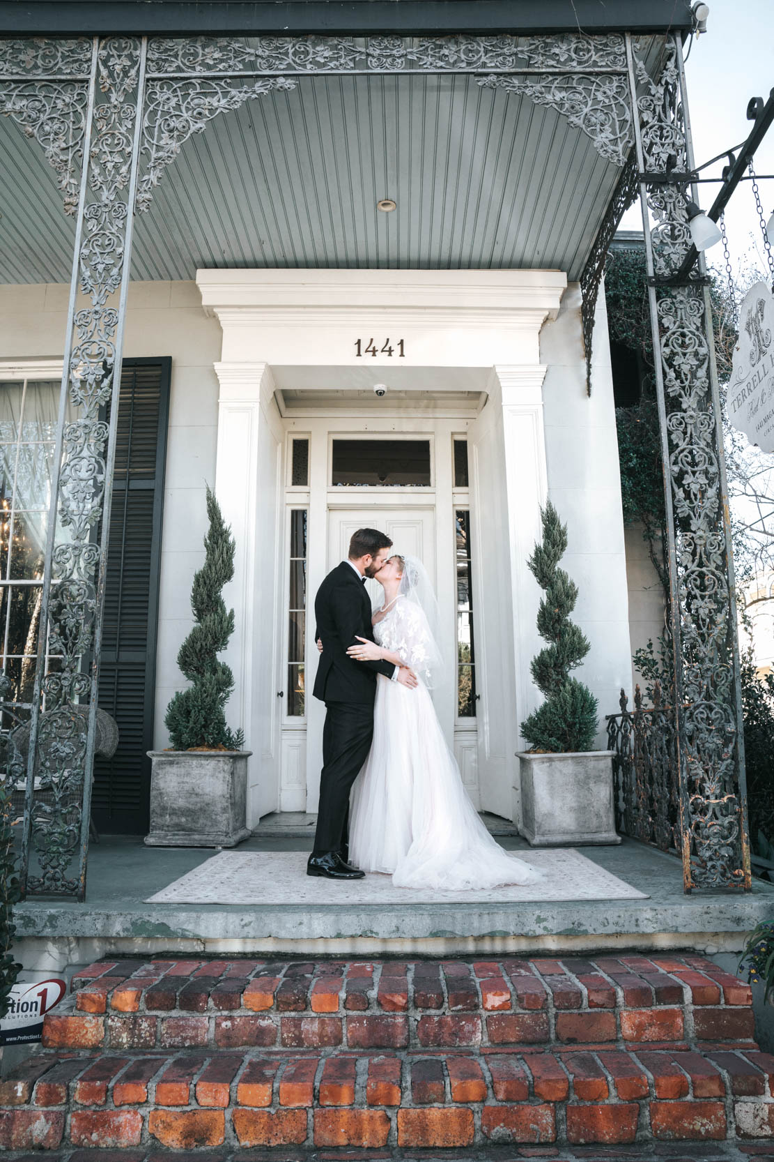 bride and groom kissing in front of Terrell House in New Orleans Lower Garden District