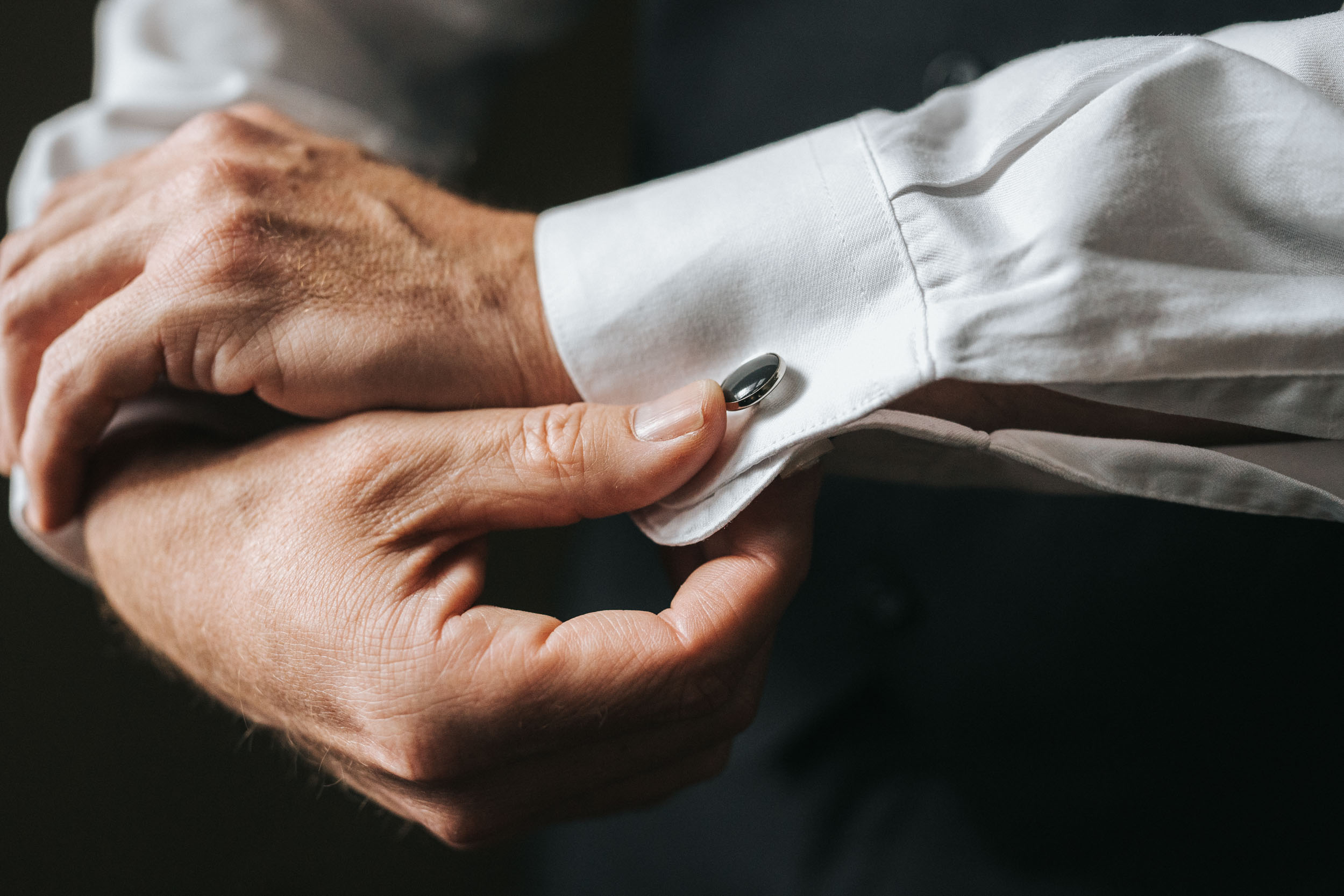 groom adjusting cuff links on wedding day