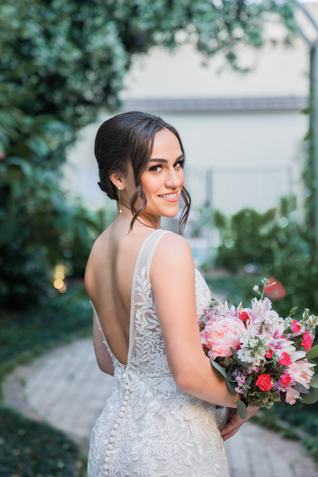 bride posing and smiling with flowers at The Southern Hotel in Covington