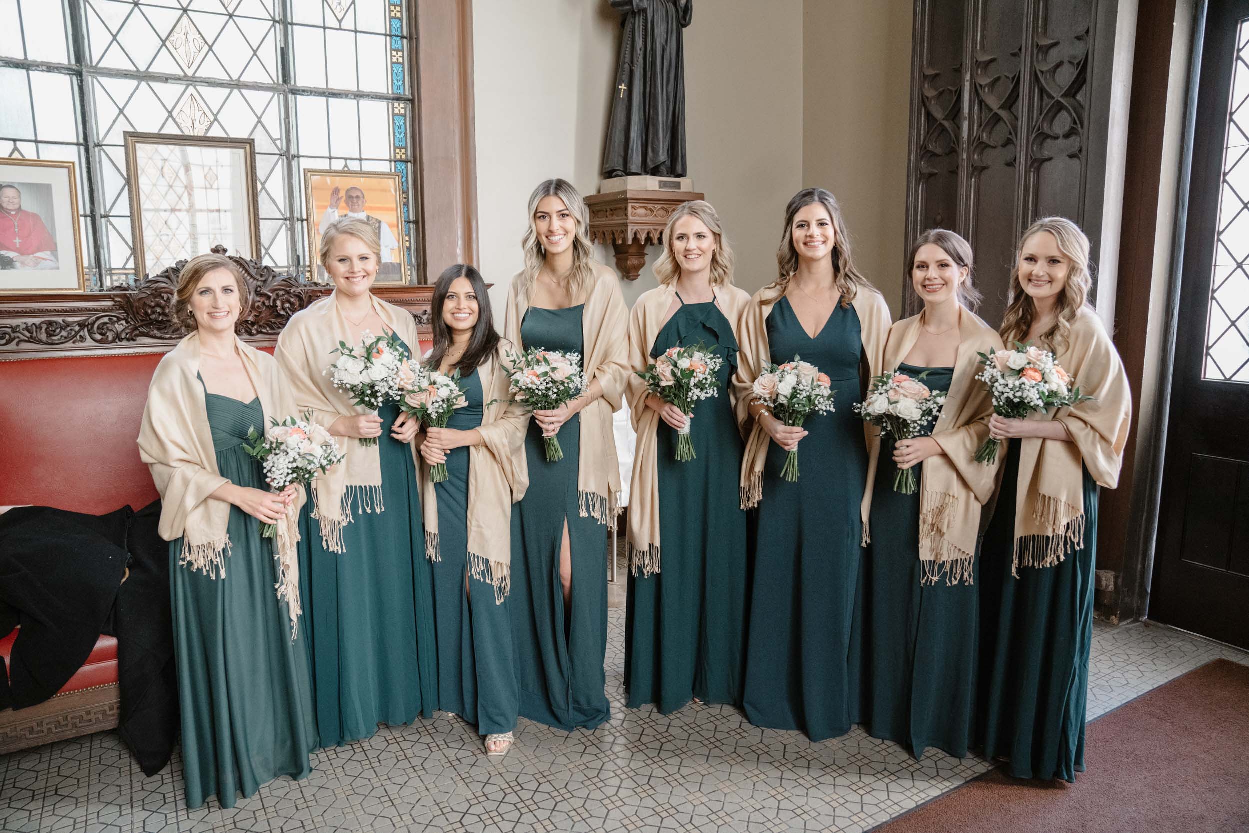 bridesmaids holding wedding flowers and smiling at Ursuline church in New Orleans