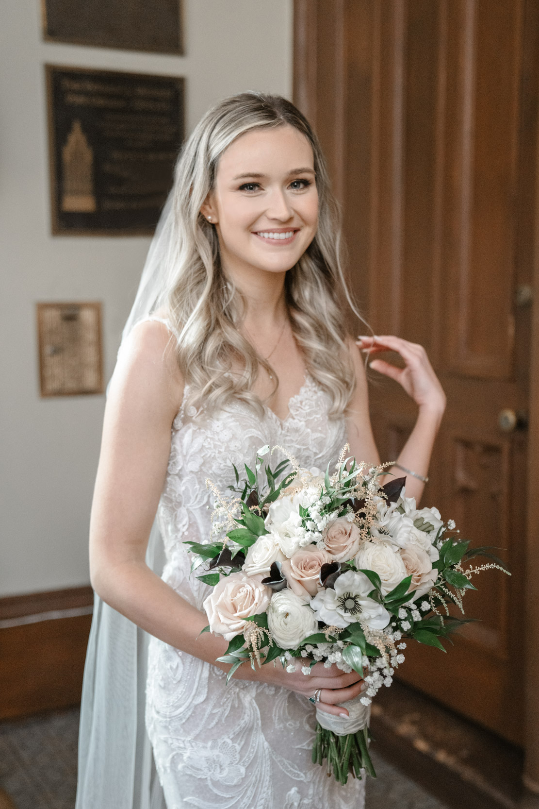 bride smiling with flowers before wedding inside St. Patrick's cathedral in New Orleans