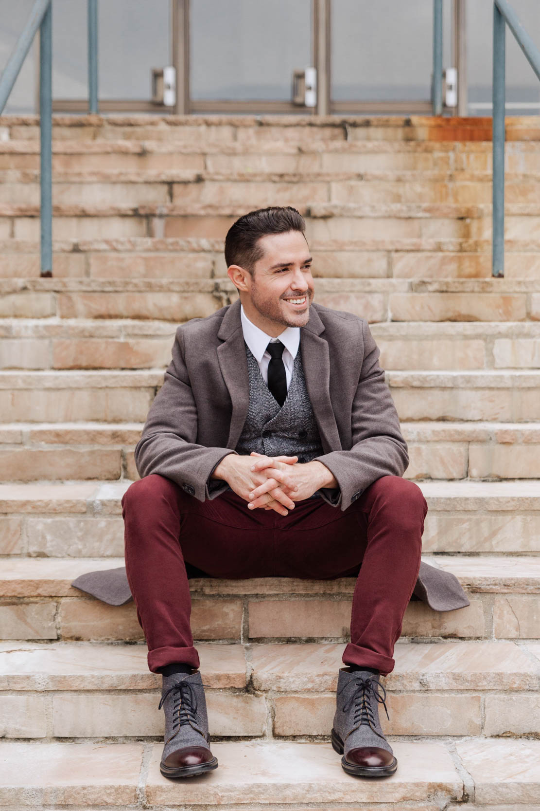 Ryan H Gray with Shades of Gray Photography smiling on stairs in Louis Armstrong Park before shooting a wedding