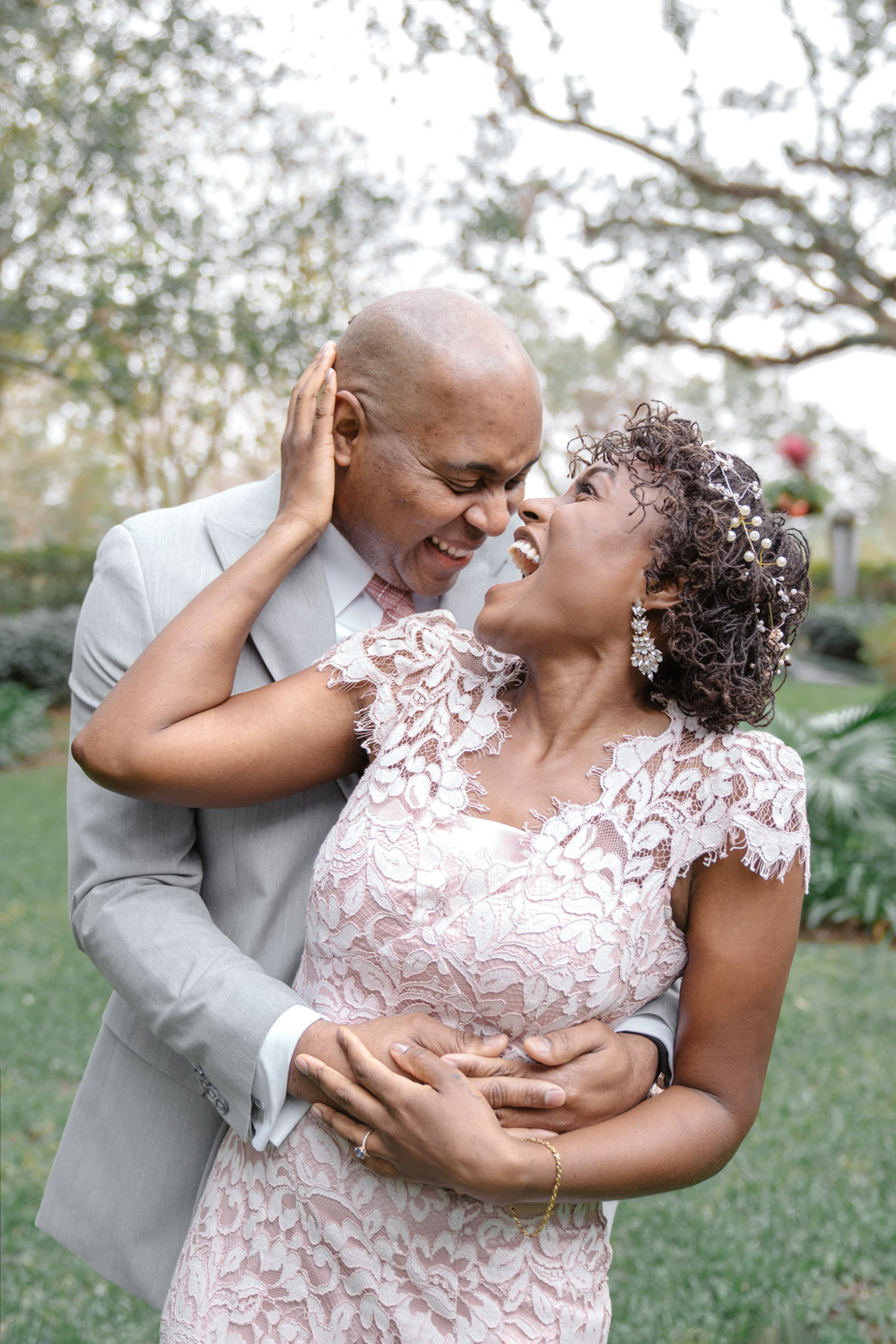 bride and groom hugging and laughing on wedding day at Audubon Park in New Orleans