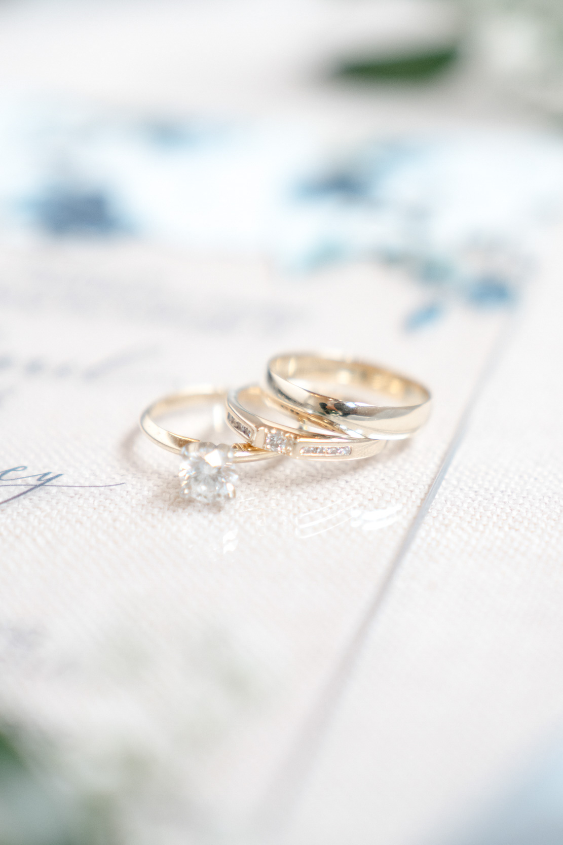 flat lay of wedding rings and invitation