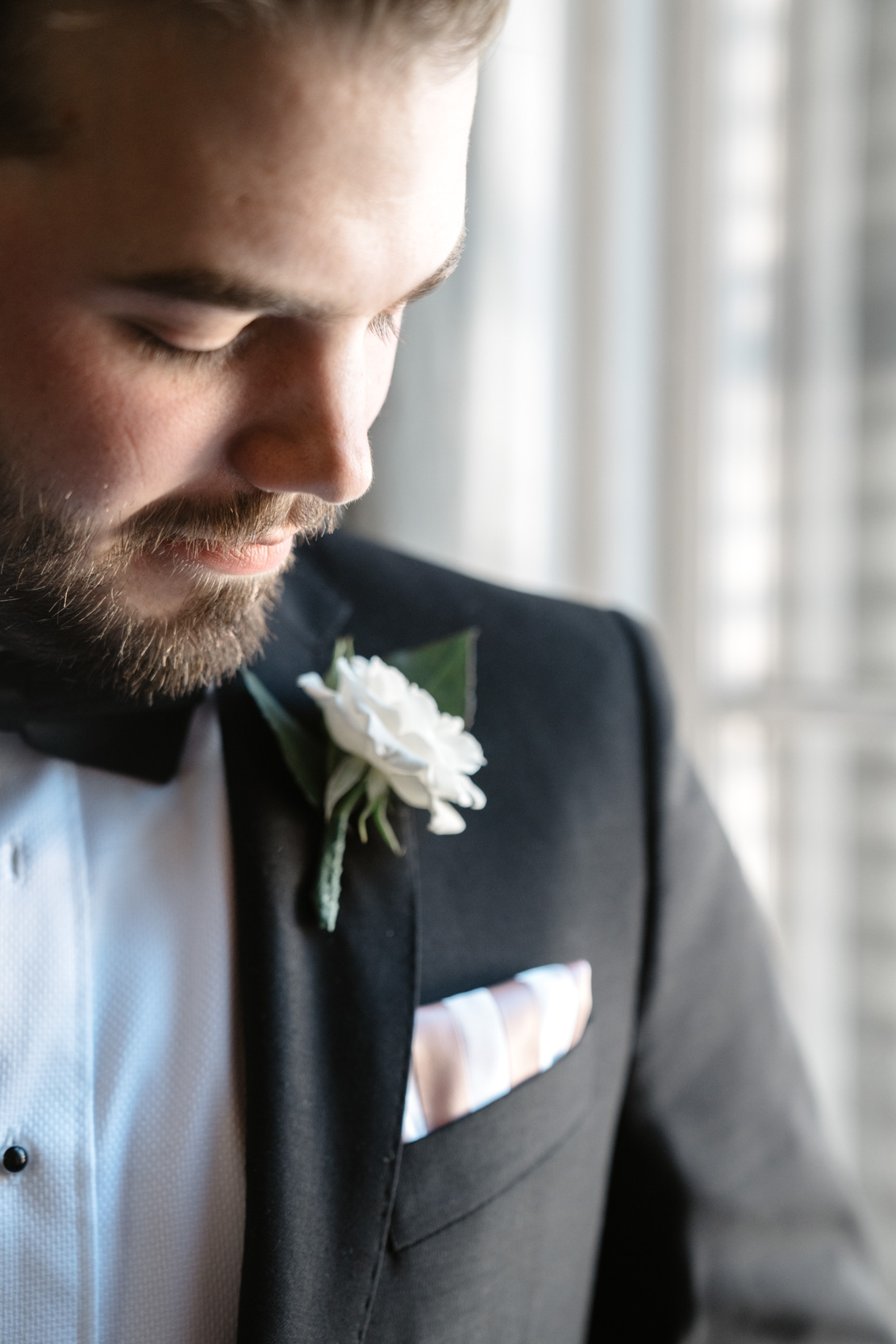 groom looking at his boutonniere at The Terrell House in New Orleans Lower Garden District