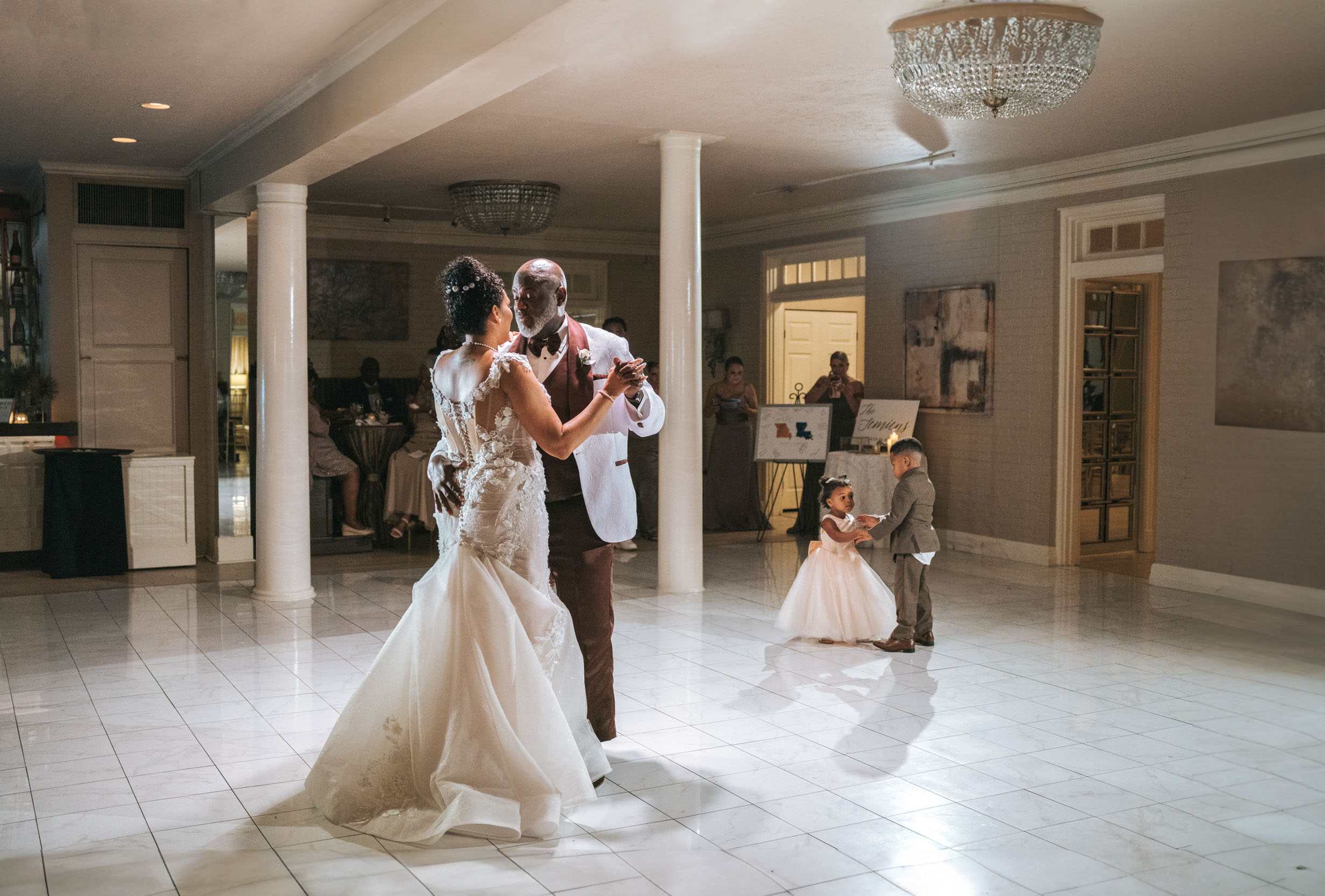 African American bride and groom dancing for their first dance with two small children next to them dancing at The Southern Oaks in New Orleans