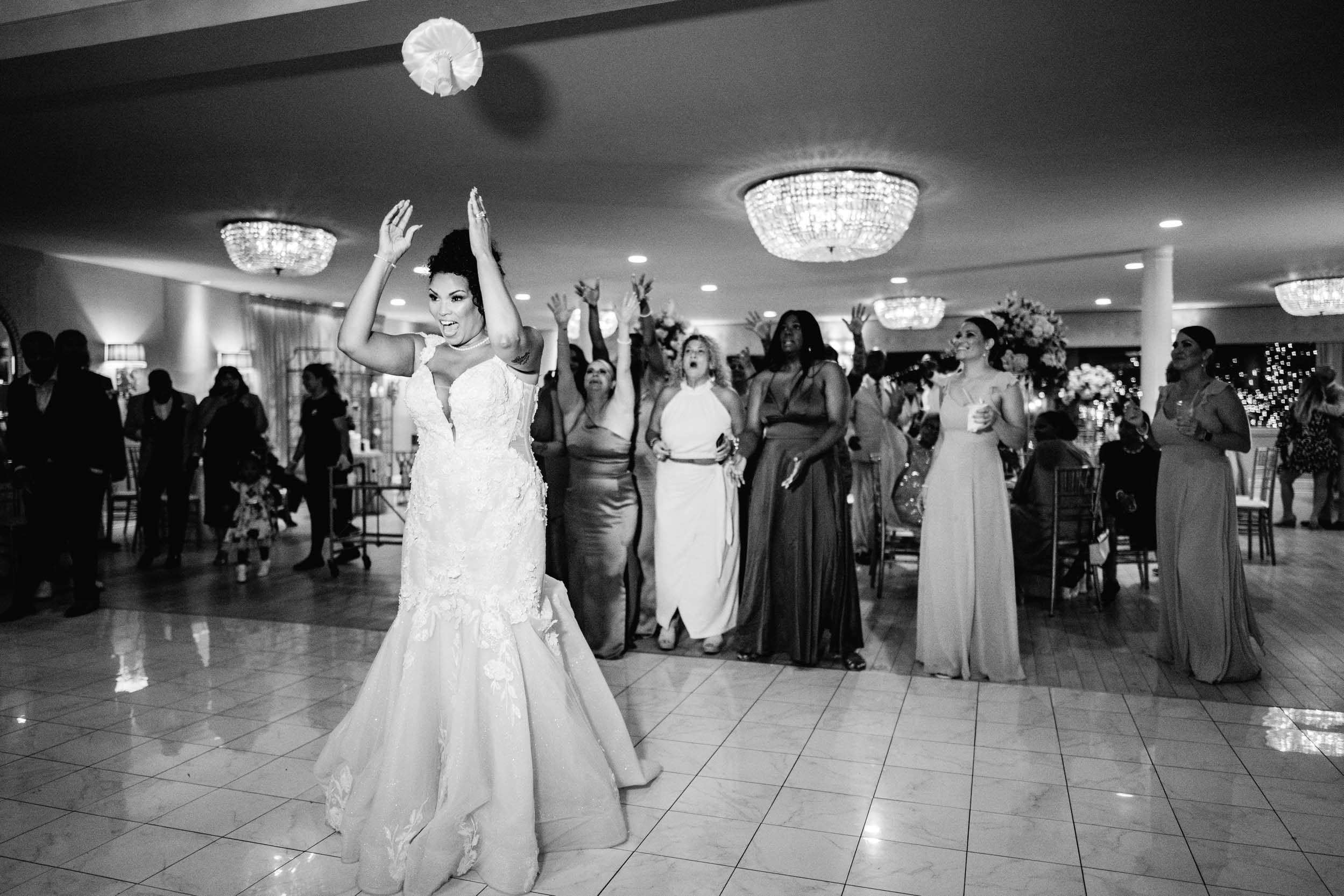 Beautiful African American bride throwing her bouquet on wedding day at The Southern Oaks in New Orleans