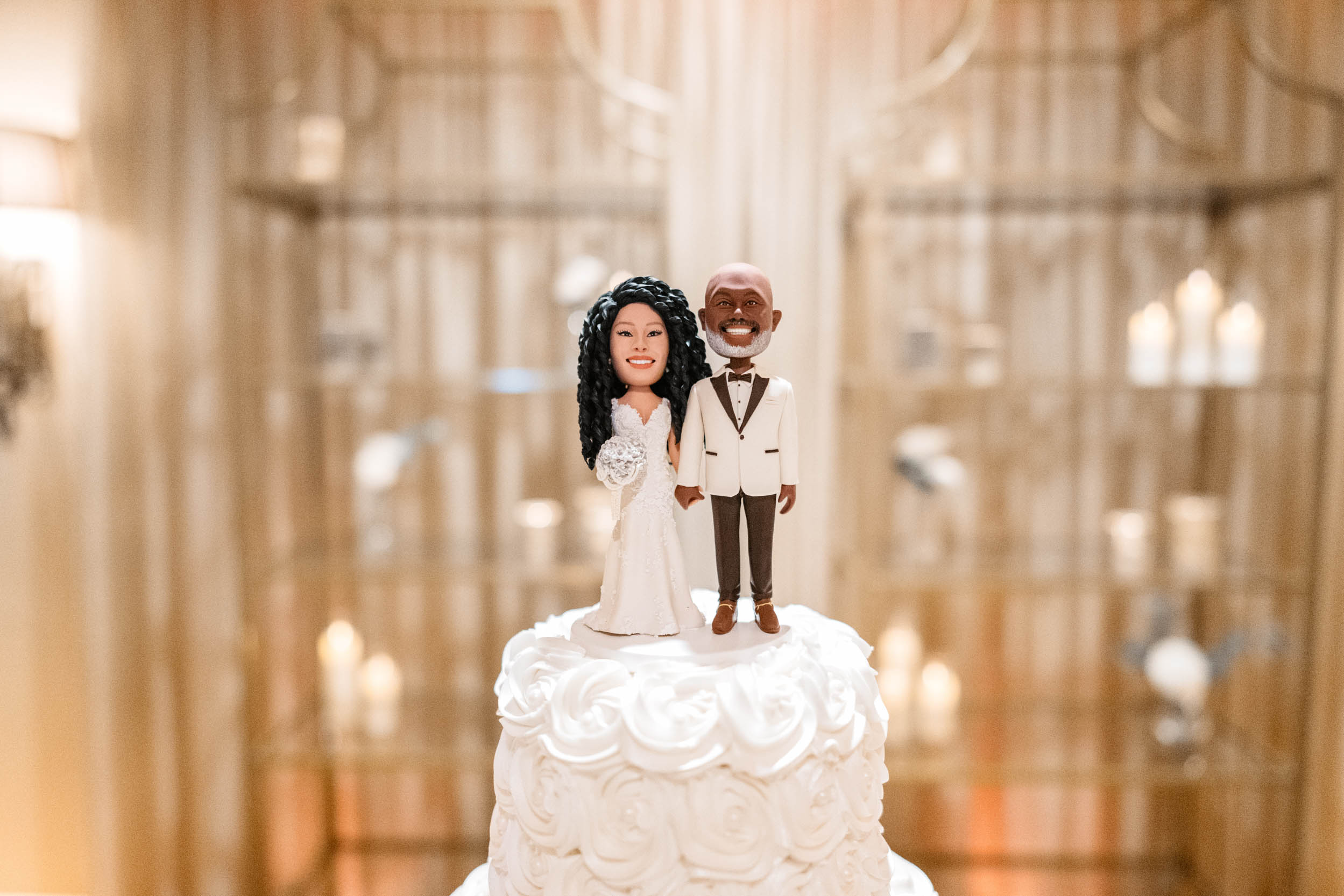 Bobble heads on wedding cake of African American bride and groom at The Southern Oaks in New Orleans