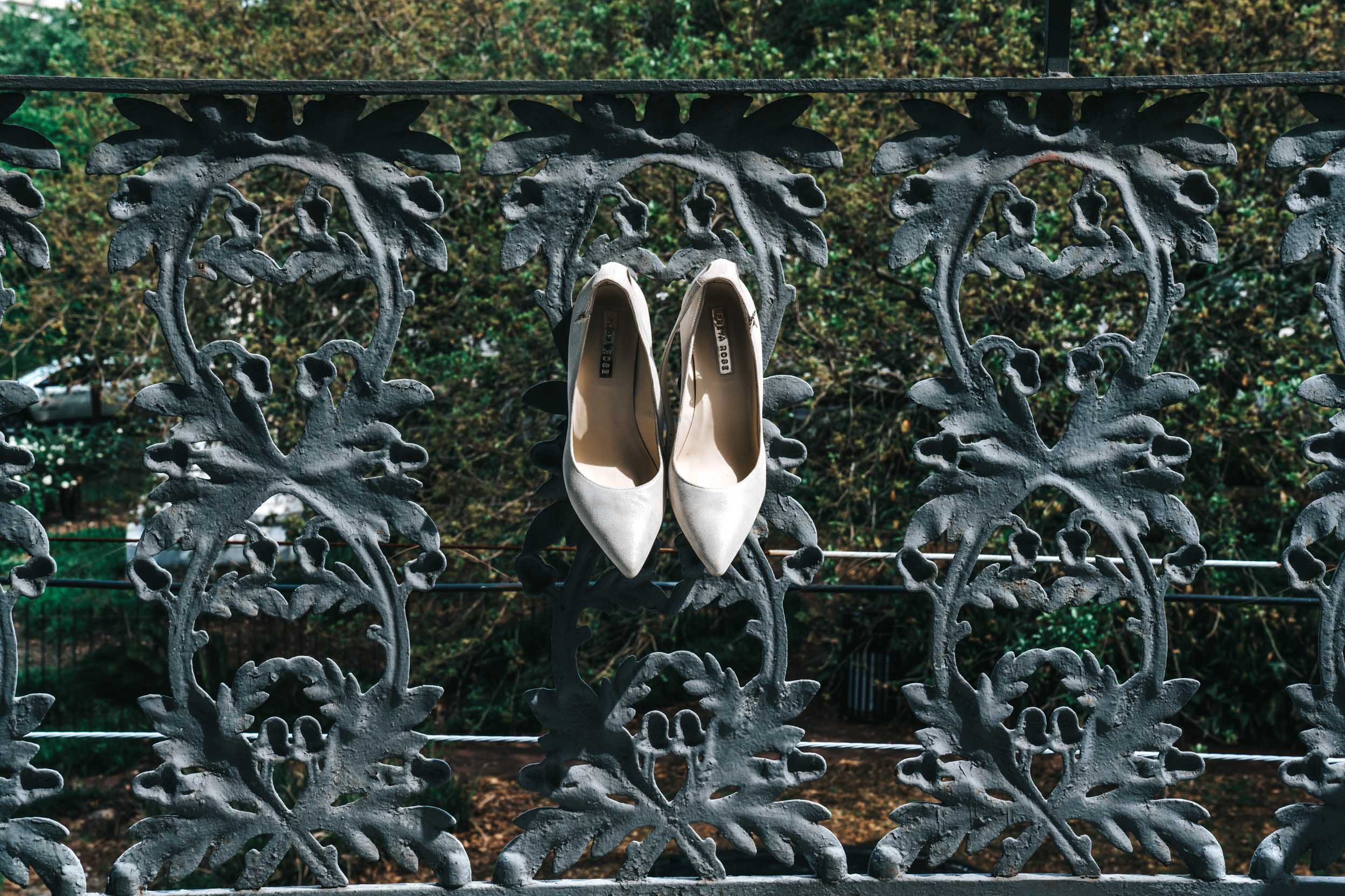 Freya Rose bridal shoes hanging from wrought iron balcony at Margaret Place in New Orleans