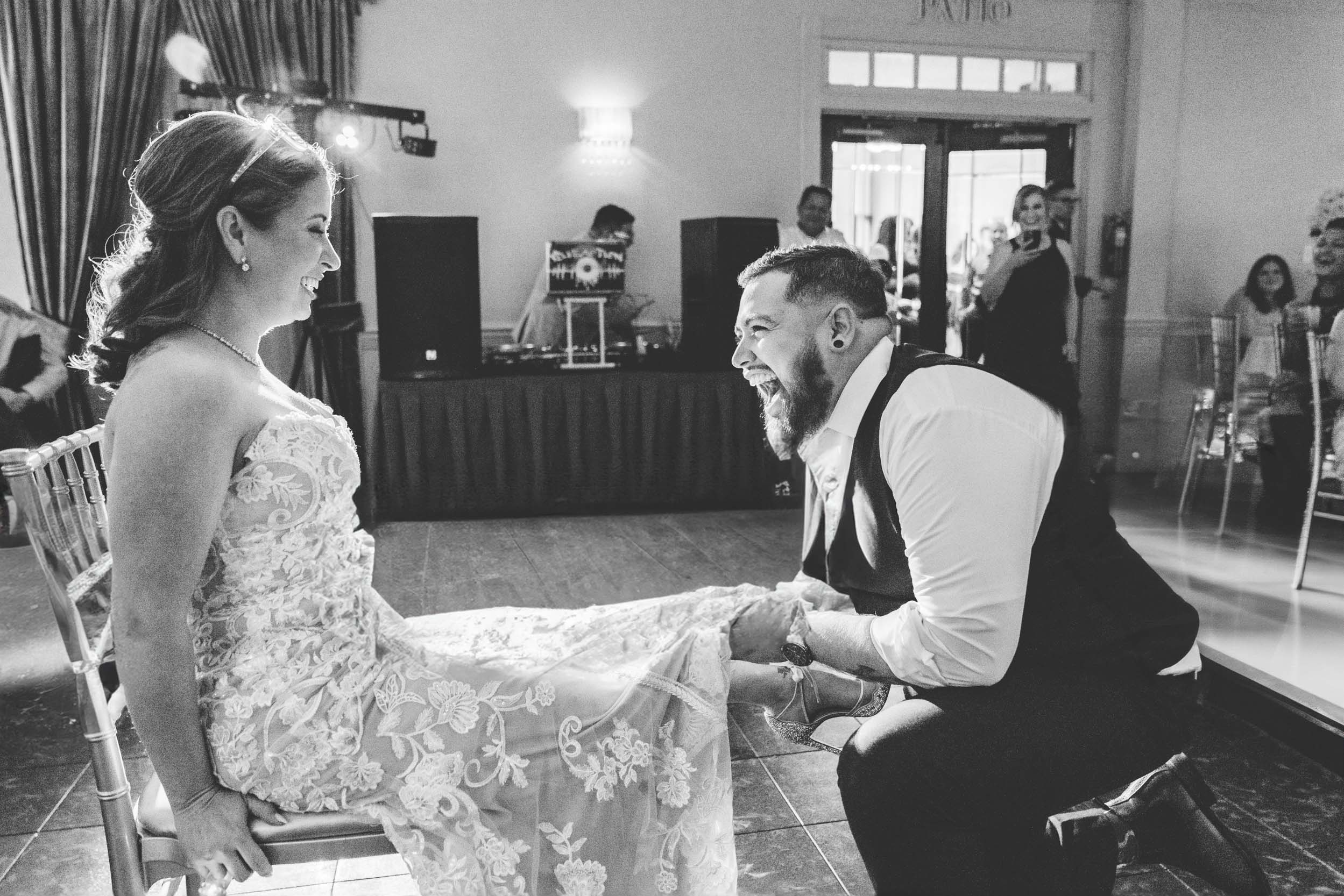 Groom pulling off bride's garter during wedding reception at Pearl Door in Harahan, Louisiana