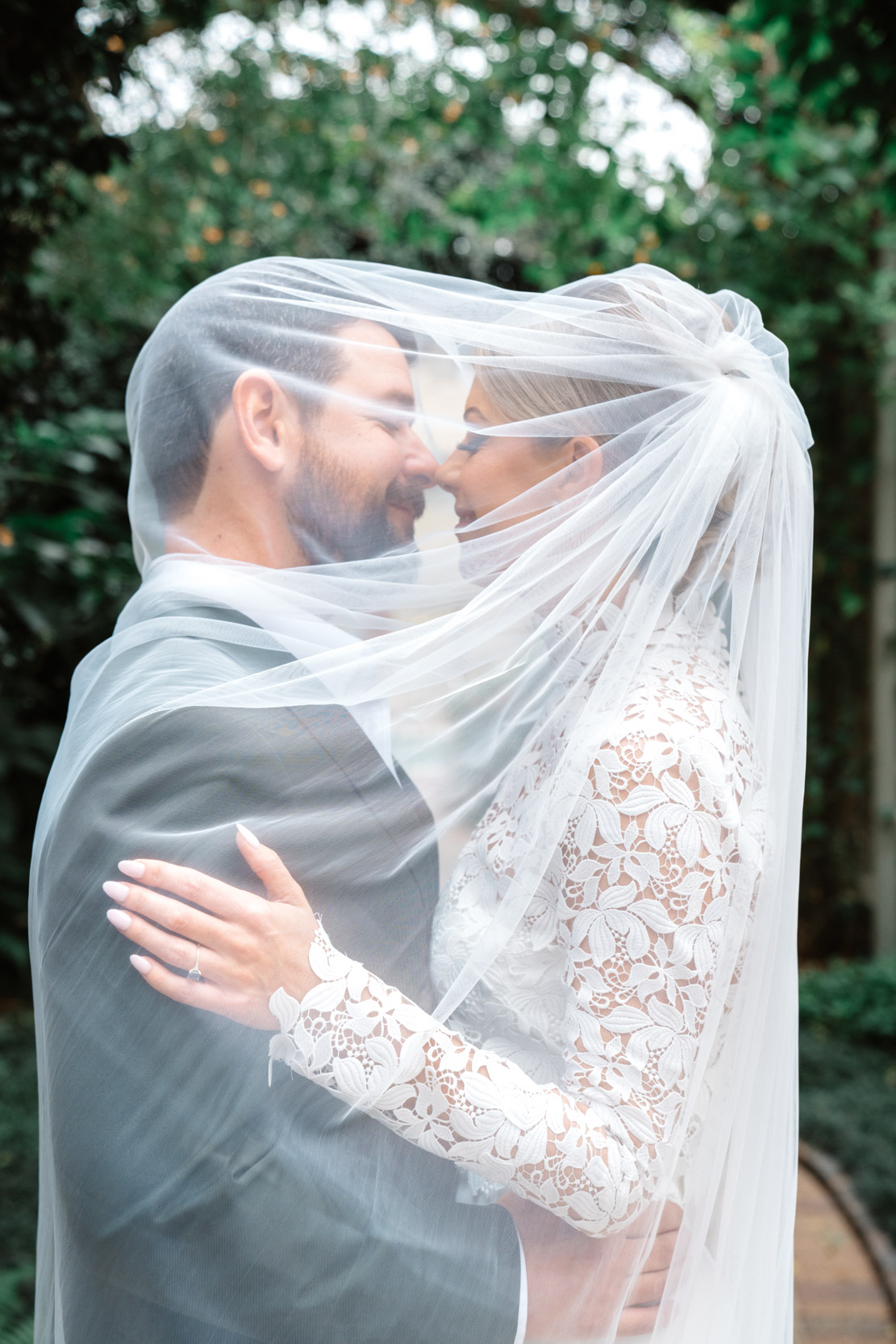 beautiful bride and groom wrapped in bridal veil at the Southern Hotel in Covington, Louisiana