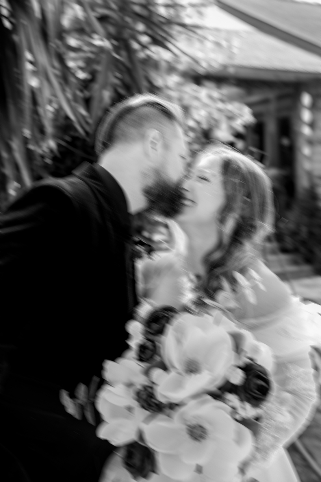 blurry wedding photo of bride and groom kissing and laughing at Emerald Door in the New Orleans Bywater