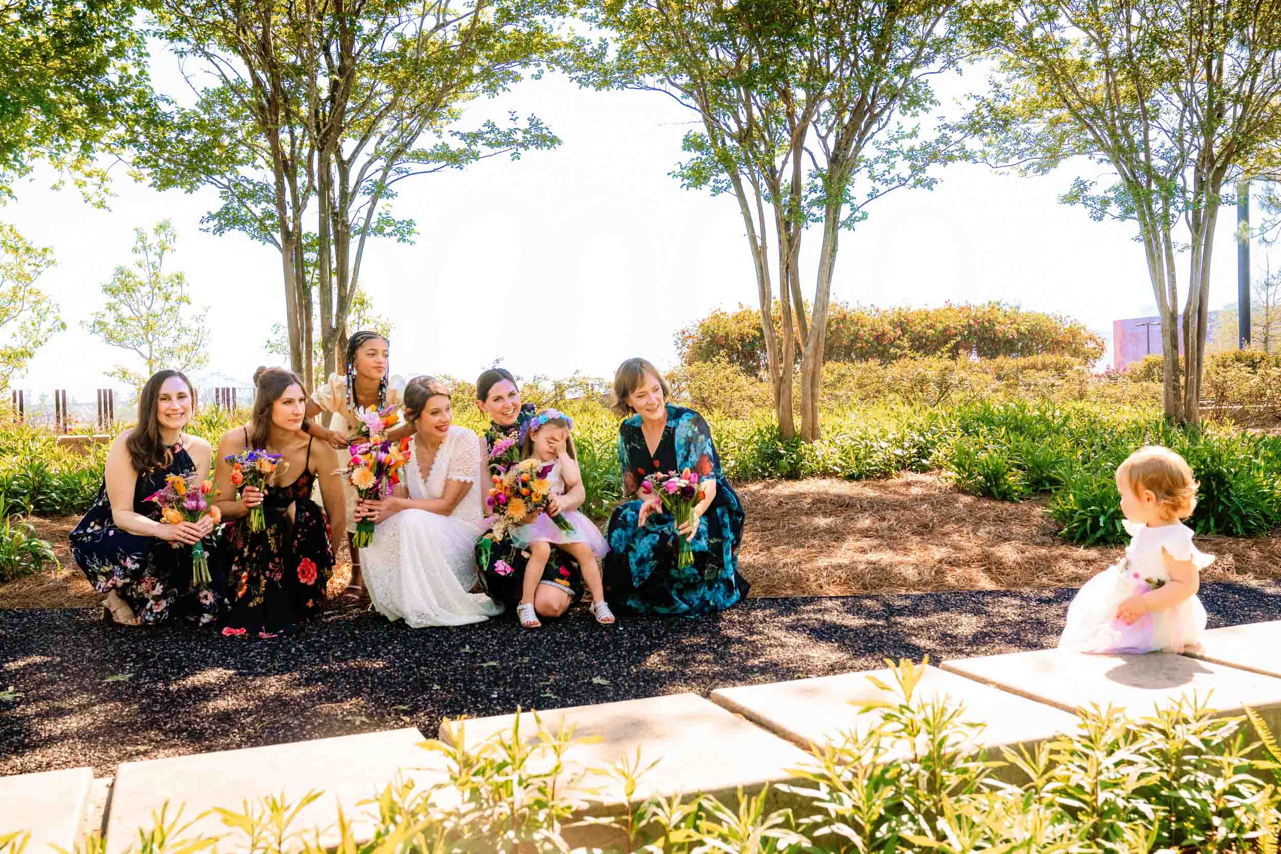 bridal party and bride admiring baby in the family at Crescent Park in the New Orleans Bywater