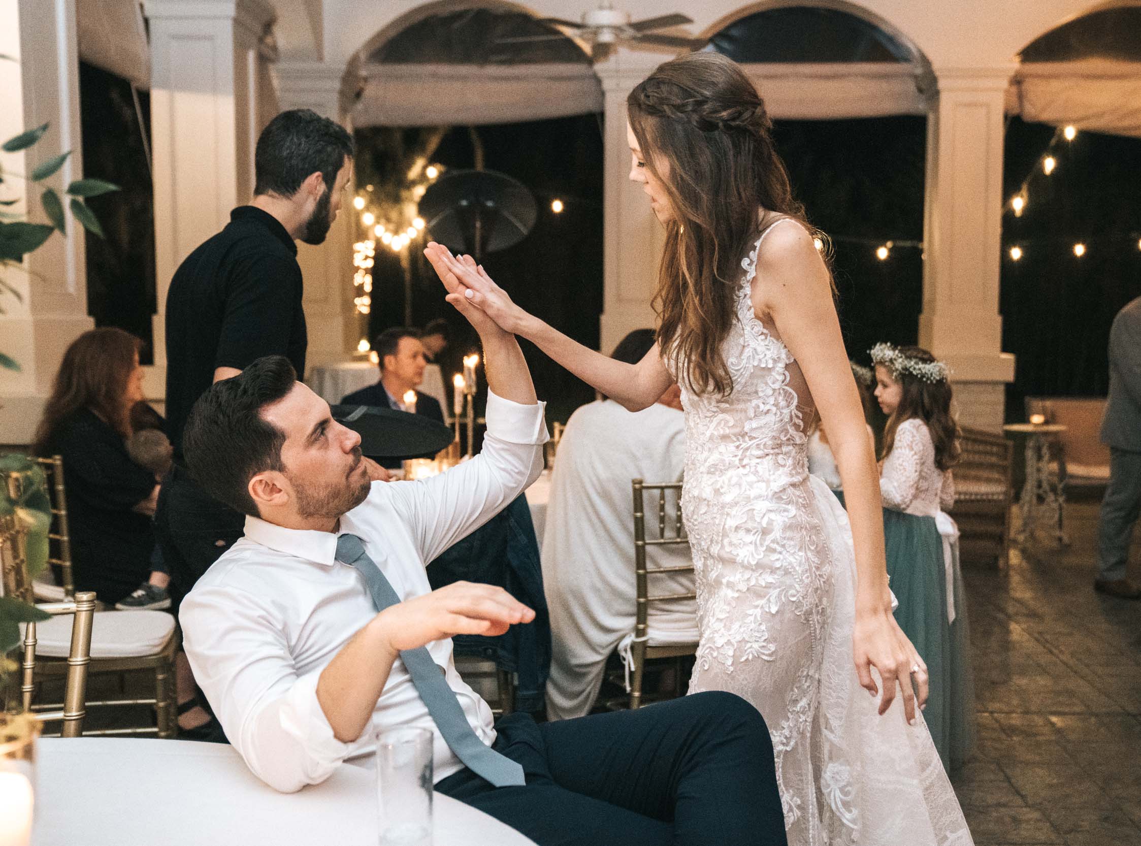 bride and groom high five each other during wedding reception at at Maison Lafitte in Covington, Louisiana