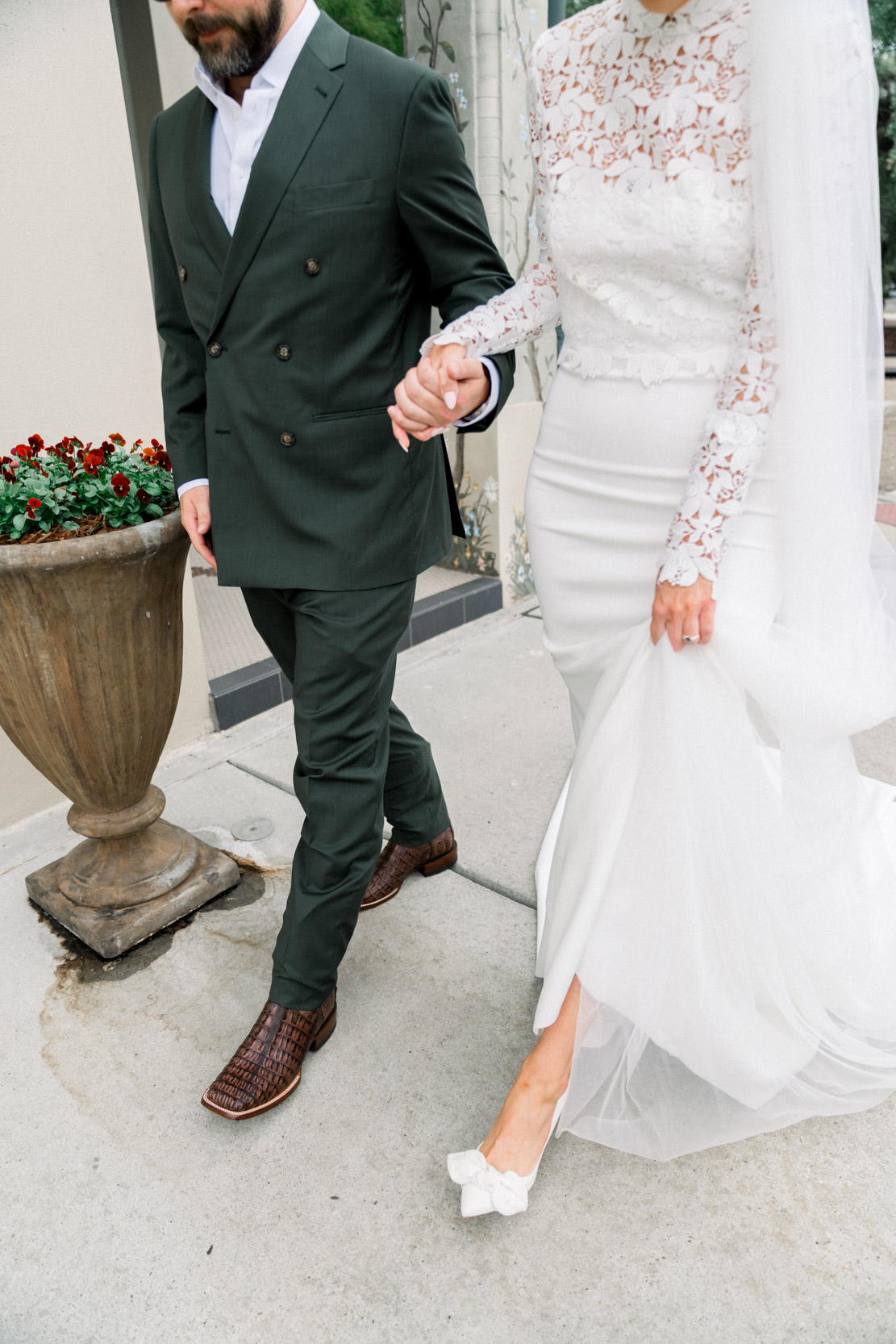 bride and groom holdings hands and walking on sidewalk at the Southern Hotel in Covington, Louisiana