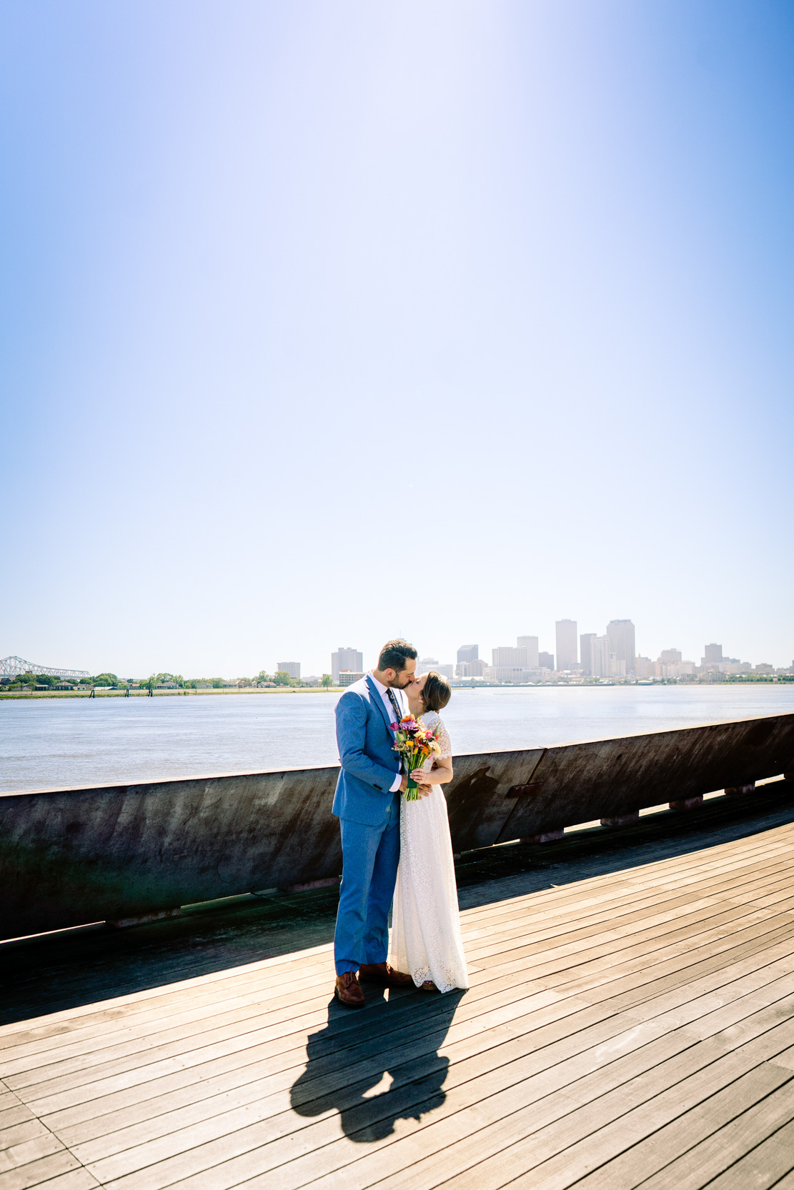 bride and groom kissing along the Mississippi River at Crescent Park in the New Orleans Bywater