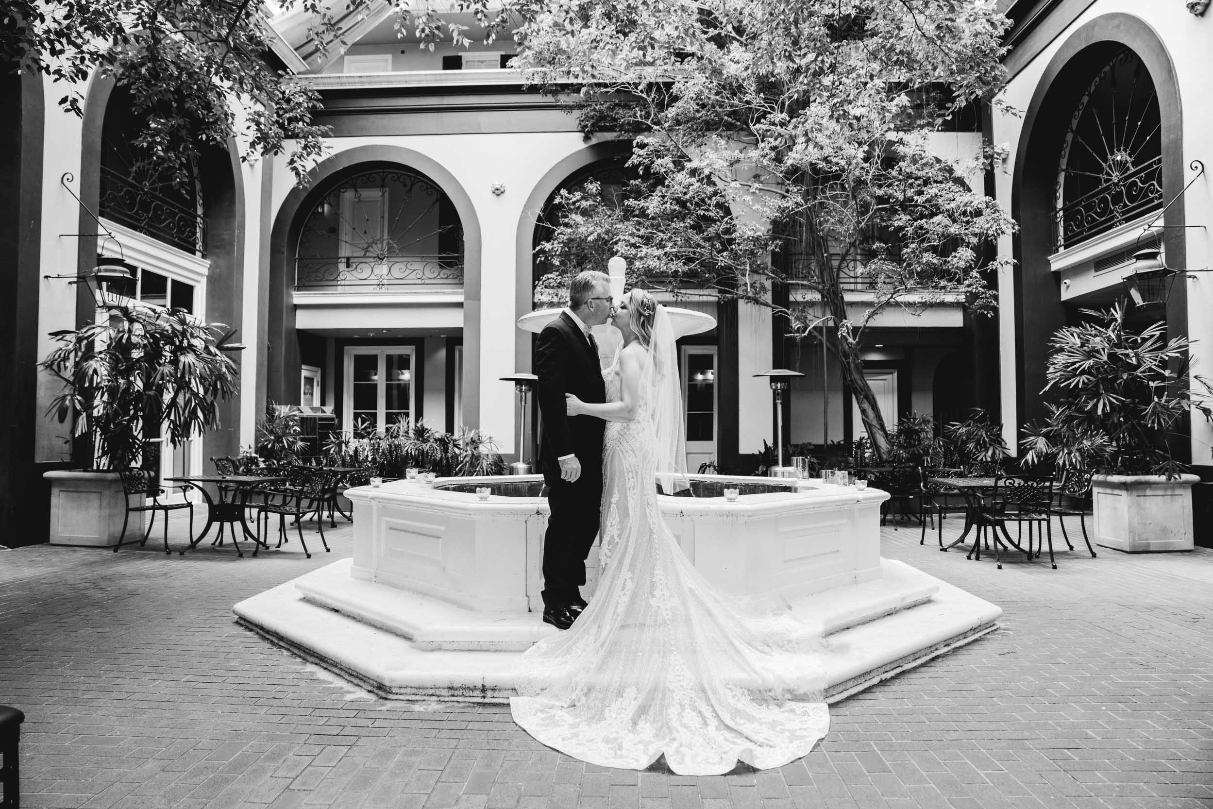 bride and groom kissing in courtyard of Hotel Mazarin in The French Quarter of New Orleans