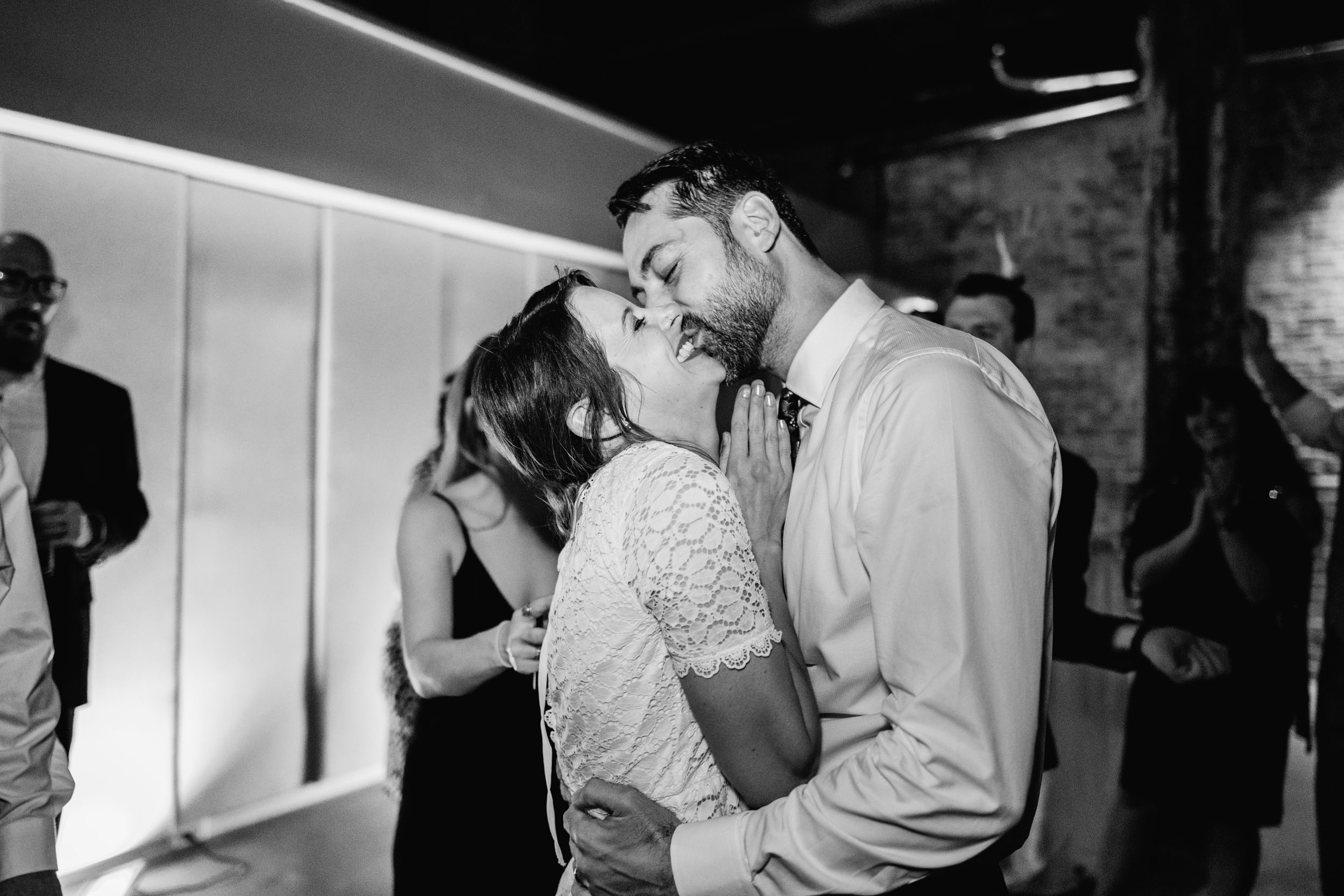 bride and groom laughing and kissing during wedding reception at Capulet in the Bywater New Orleans