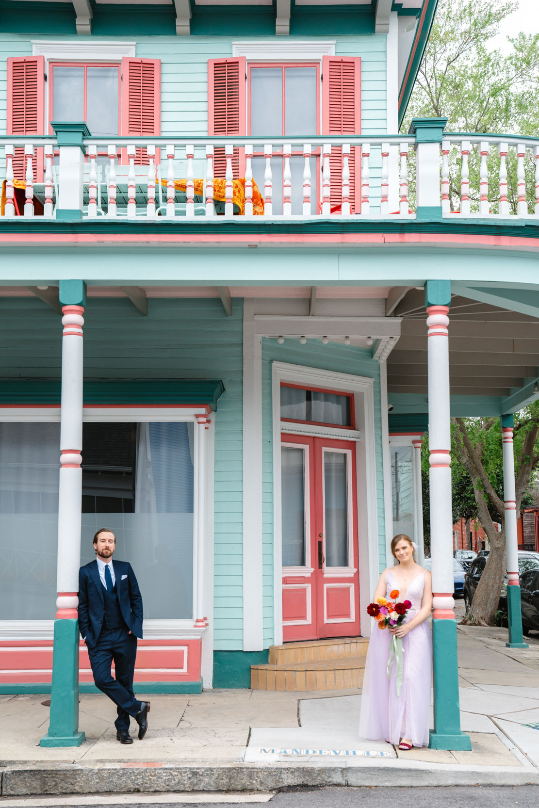 bride and groom looking at each other in front of a colorful house in the New Orleans Bywater