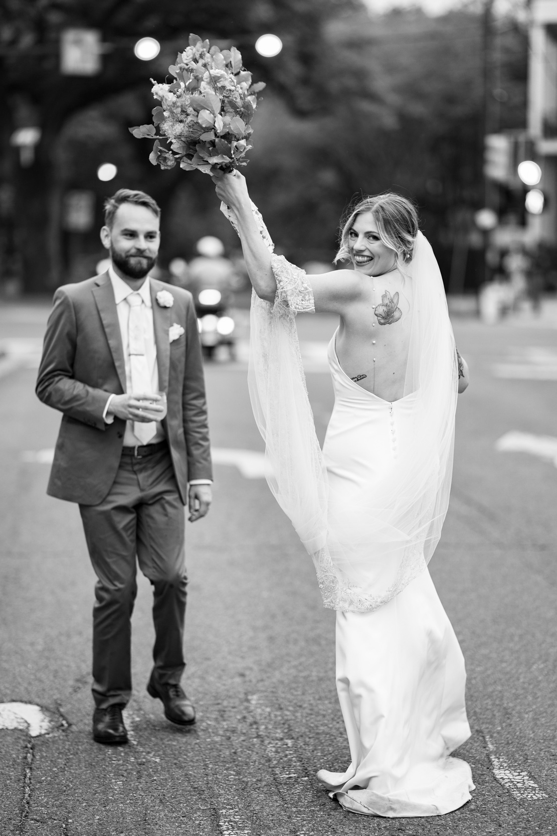 bride and groom looking back during 2nd line band procession in the Lower Garden District of New Orleans