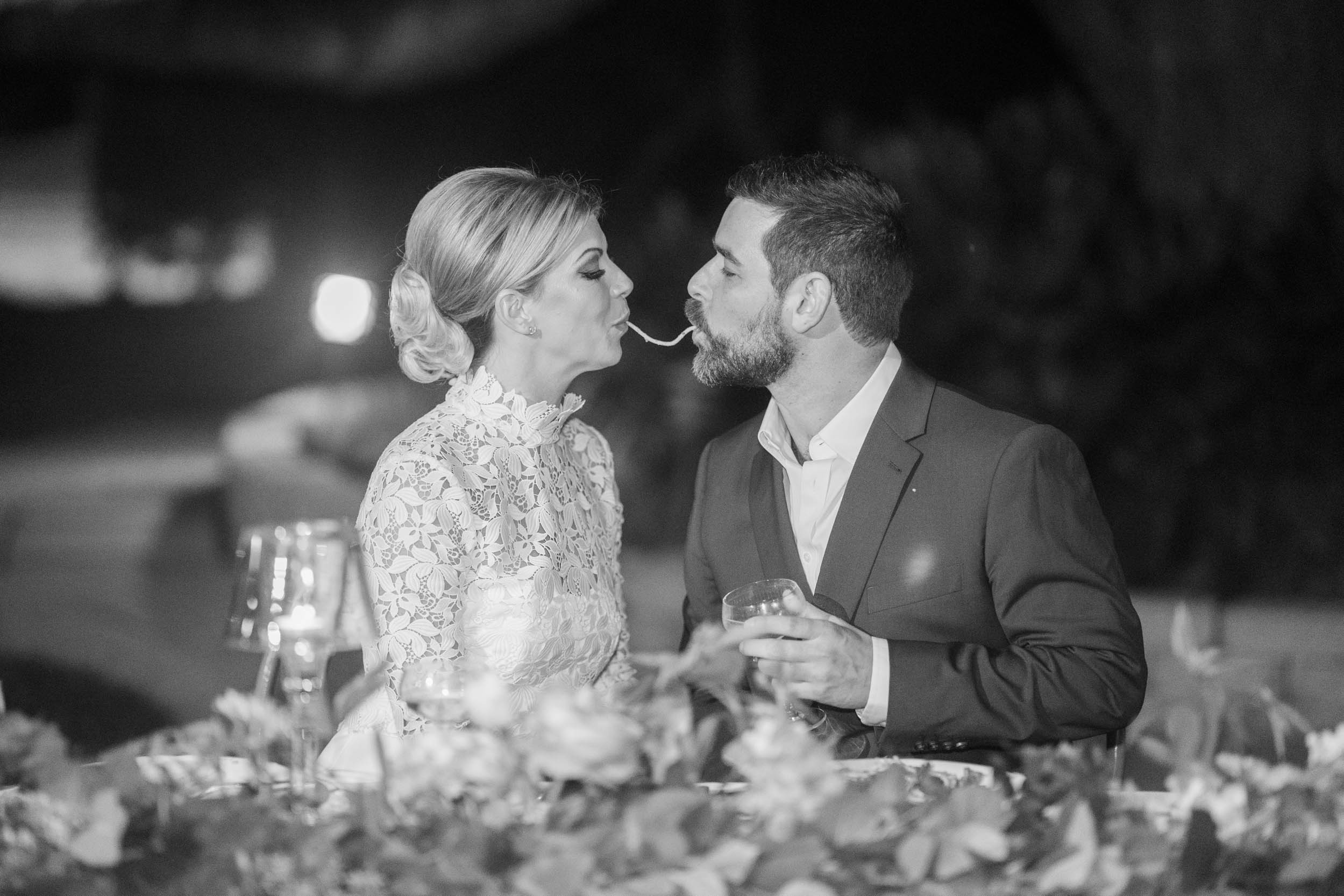 bride and groom perform a Lady and the Tramp moment with spaghetti during wedding reception at The Greenwood Covington, Louisiana