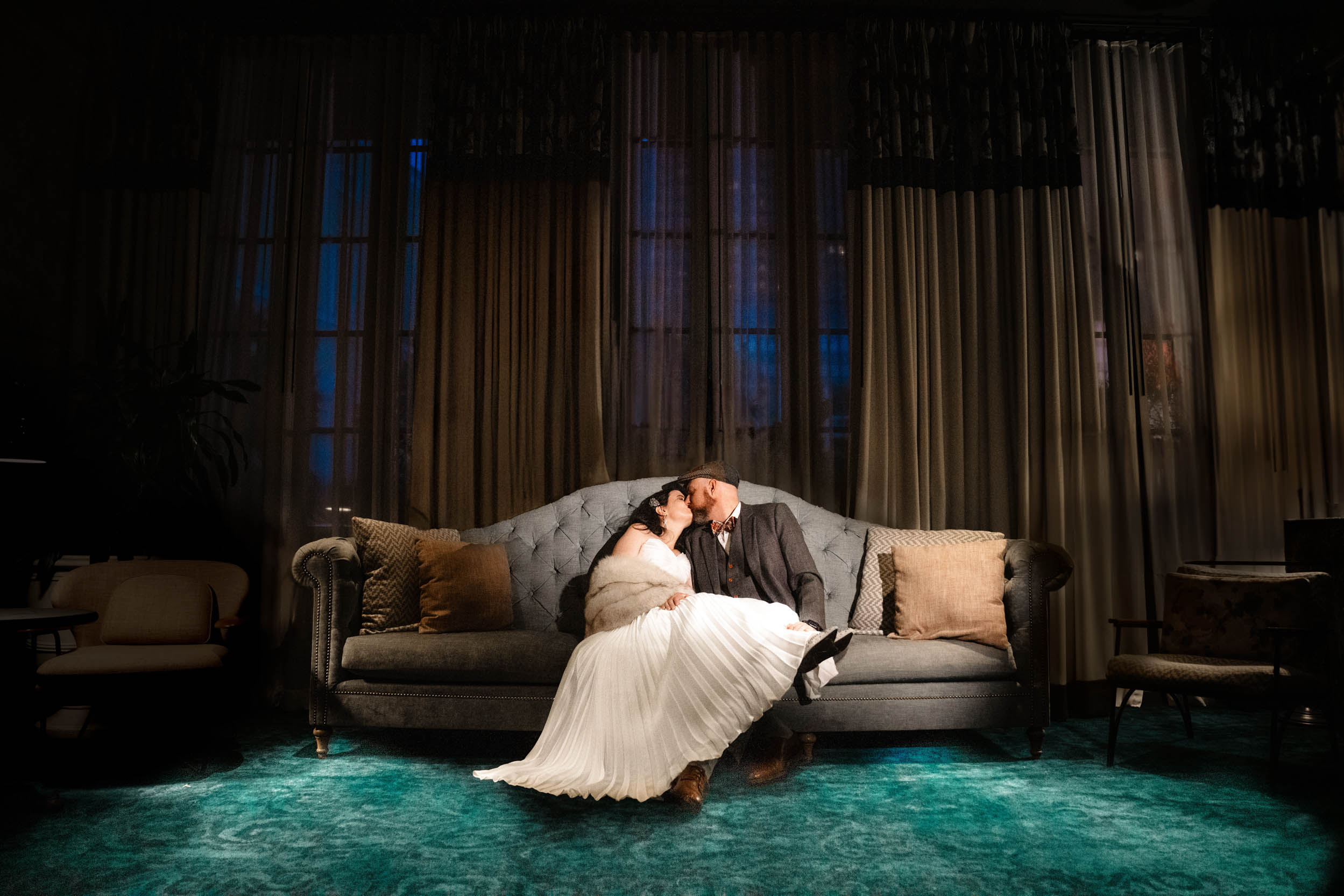 bride and groom sitting on couch and kissing at The Eliza Jane Hotel in New Orleans