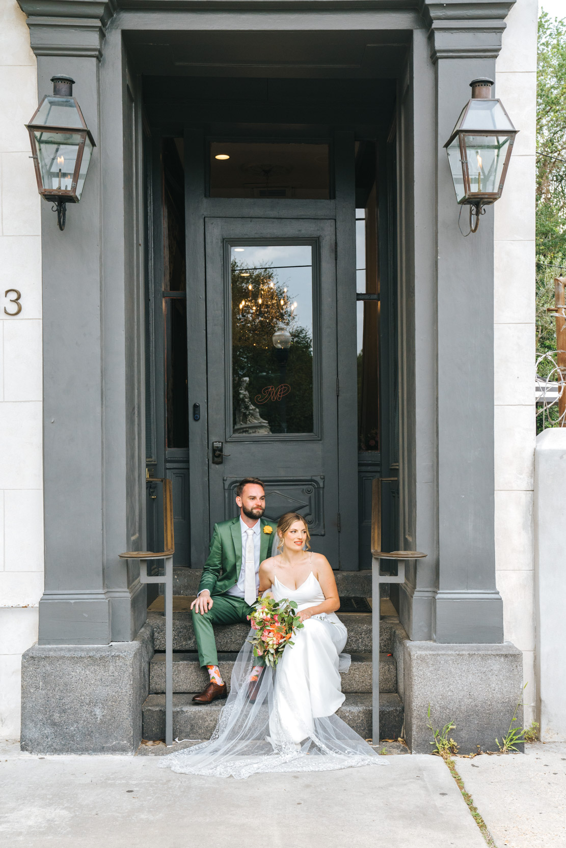 bride and groom sitting on the front steps of Margaret Place in New Orleans