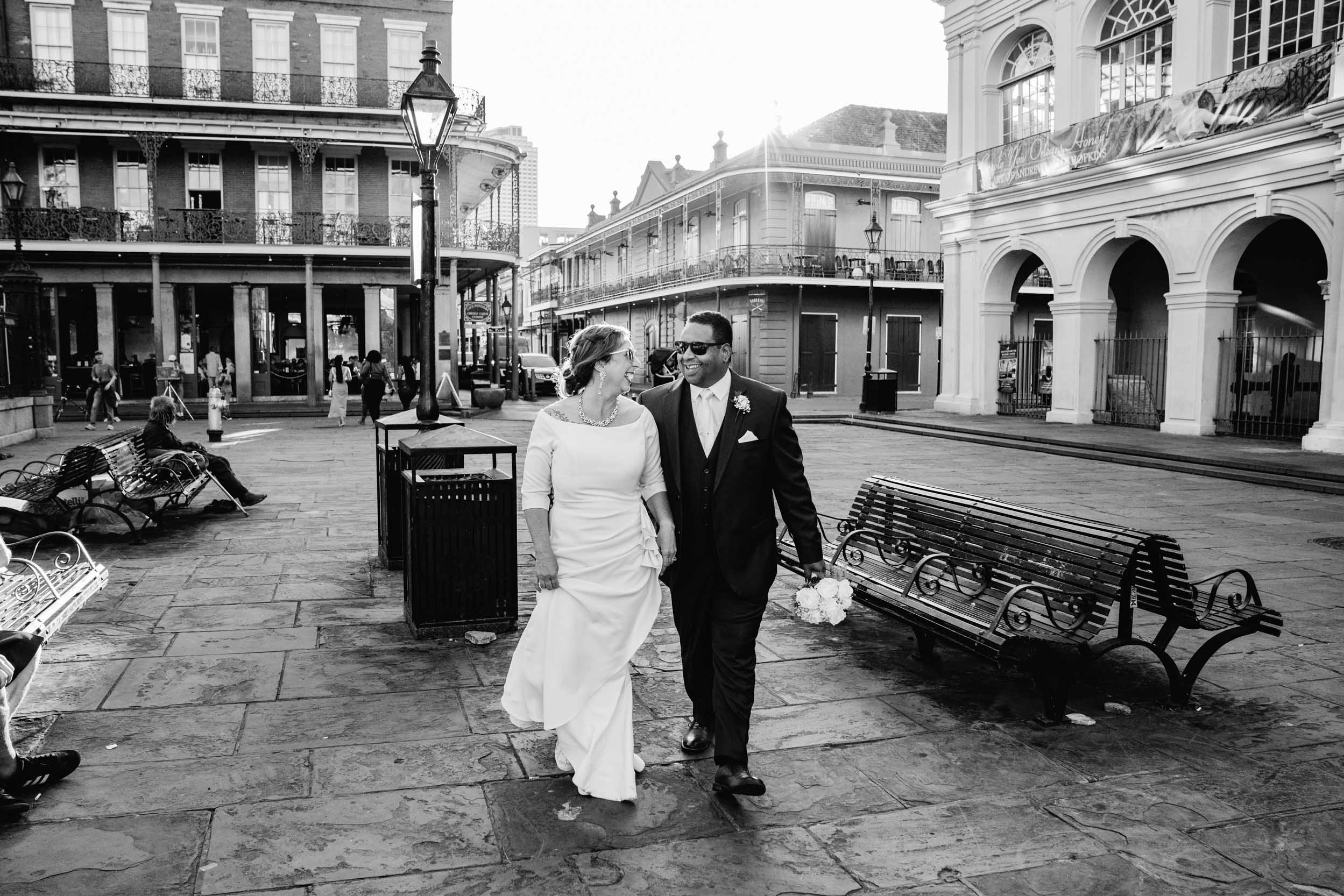 bride and groom wearing sunglasses and walking in the French Quarter of New Orleans