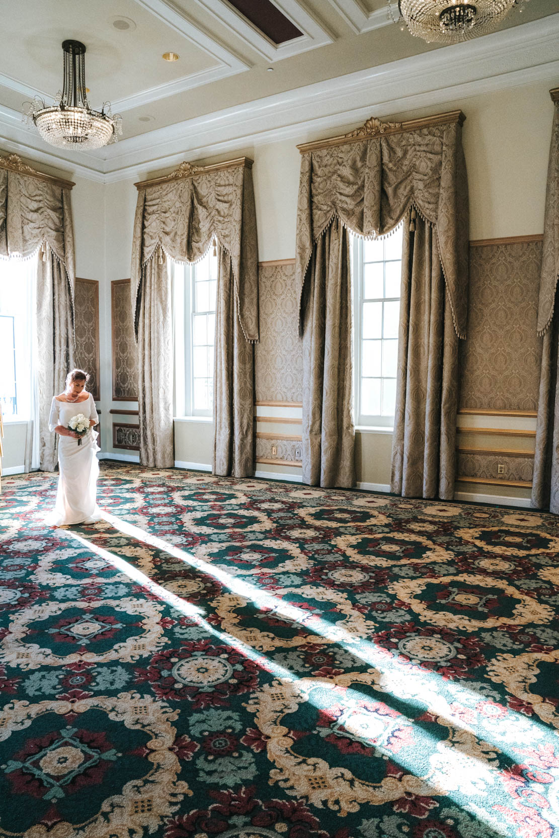 bride posing with silhouette casted from window in the main ballroom of the Bourbon Orleans Hotel in the New Orleans French Quarter