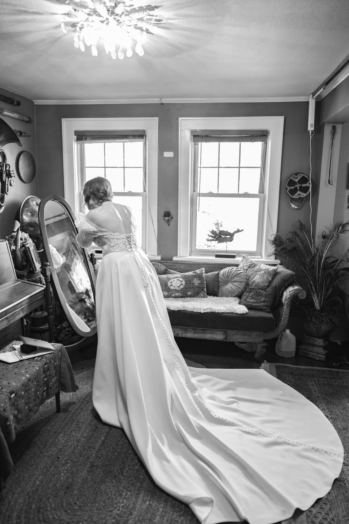 bride putting on her earrings in mirror at Emerald Door in the New Orleans Bywater