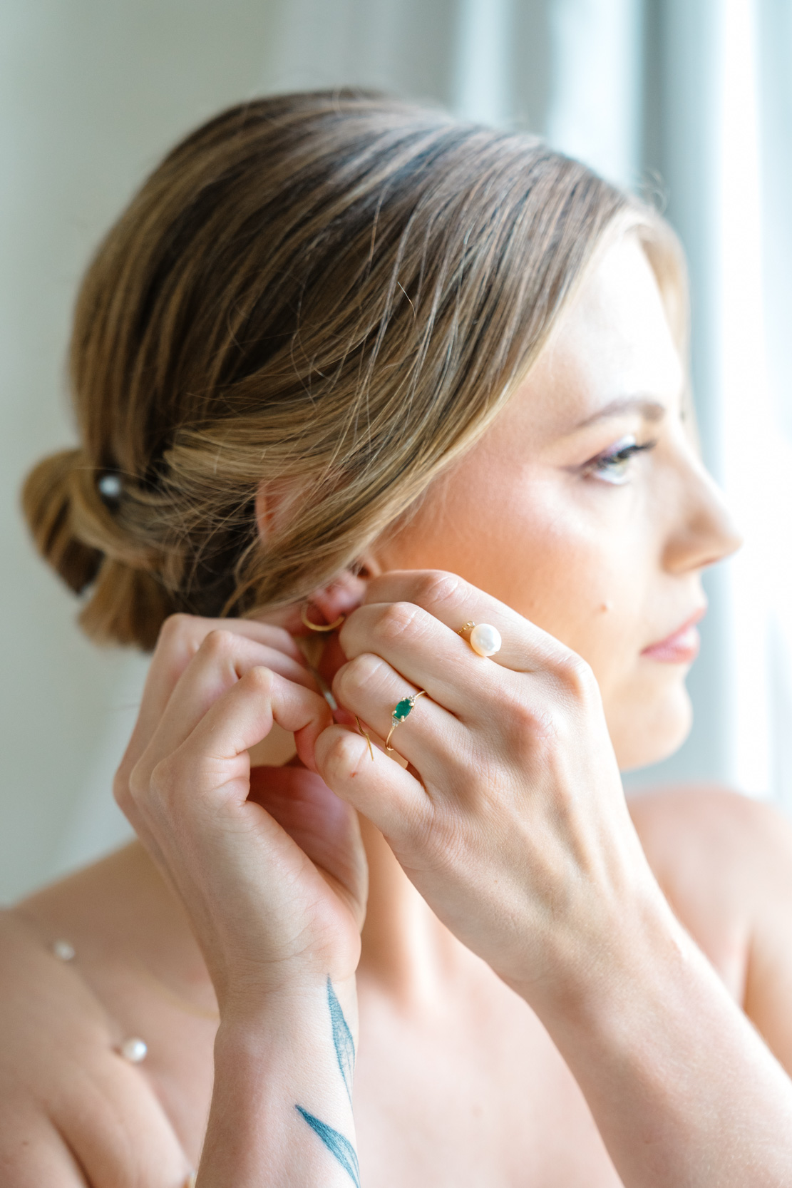 bride putting on her earrings on wedding day at Margaret Place in New Orleans