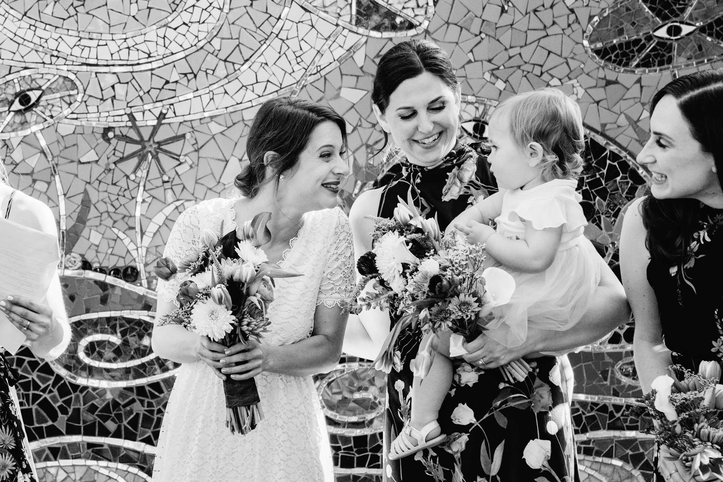 bride smiling at baby during her wedding ceremony at Clouet Gardens in the Bywater of New Orleans