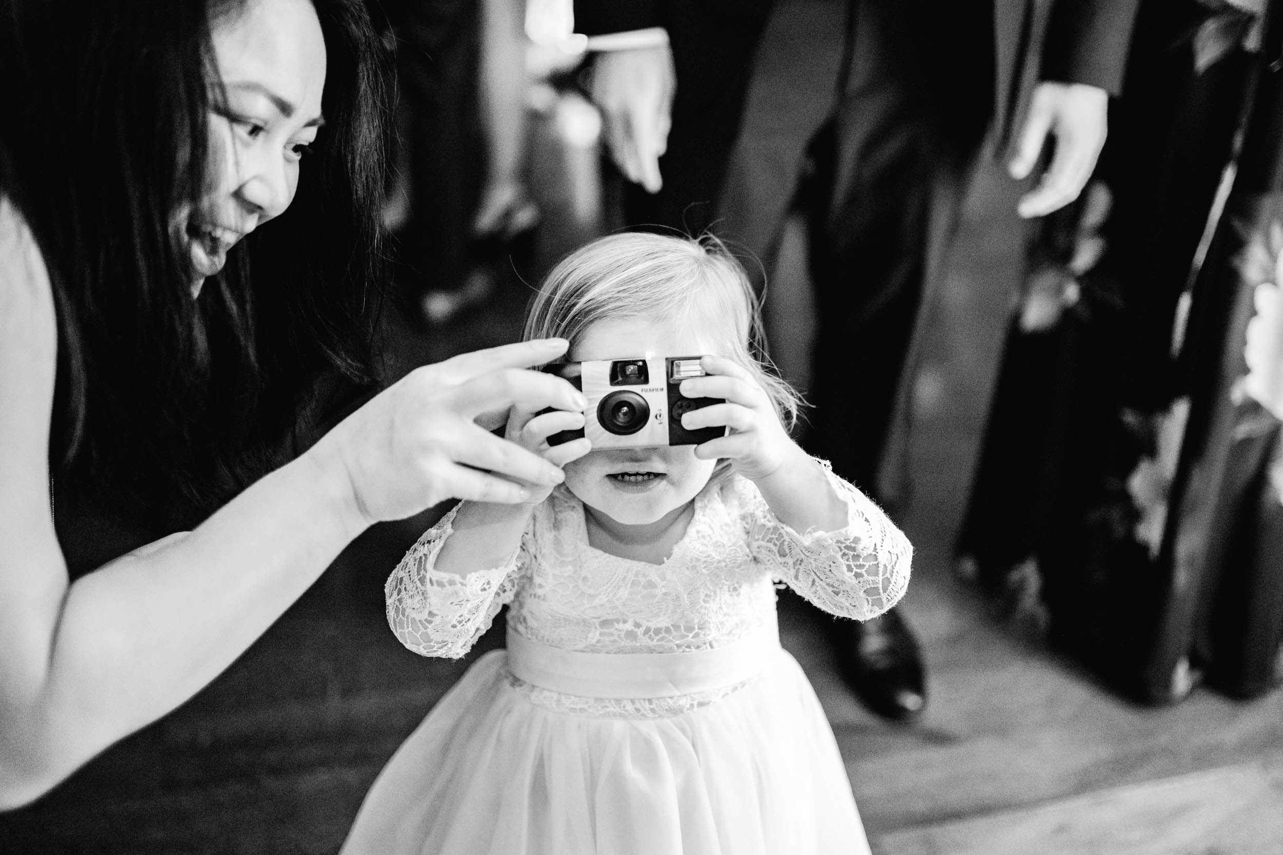 child holding polaroid camera during wedding reception at the Riverview Room in New Orleans