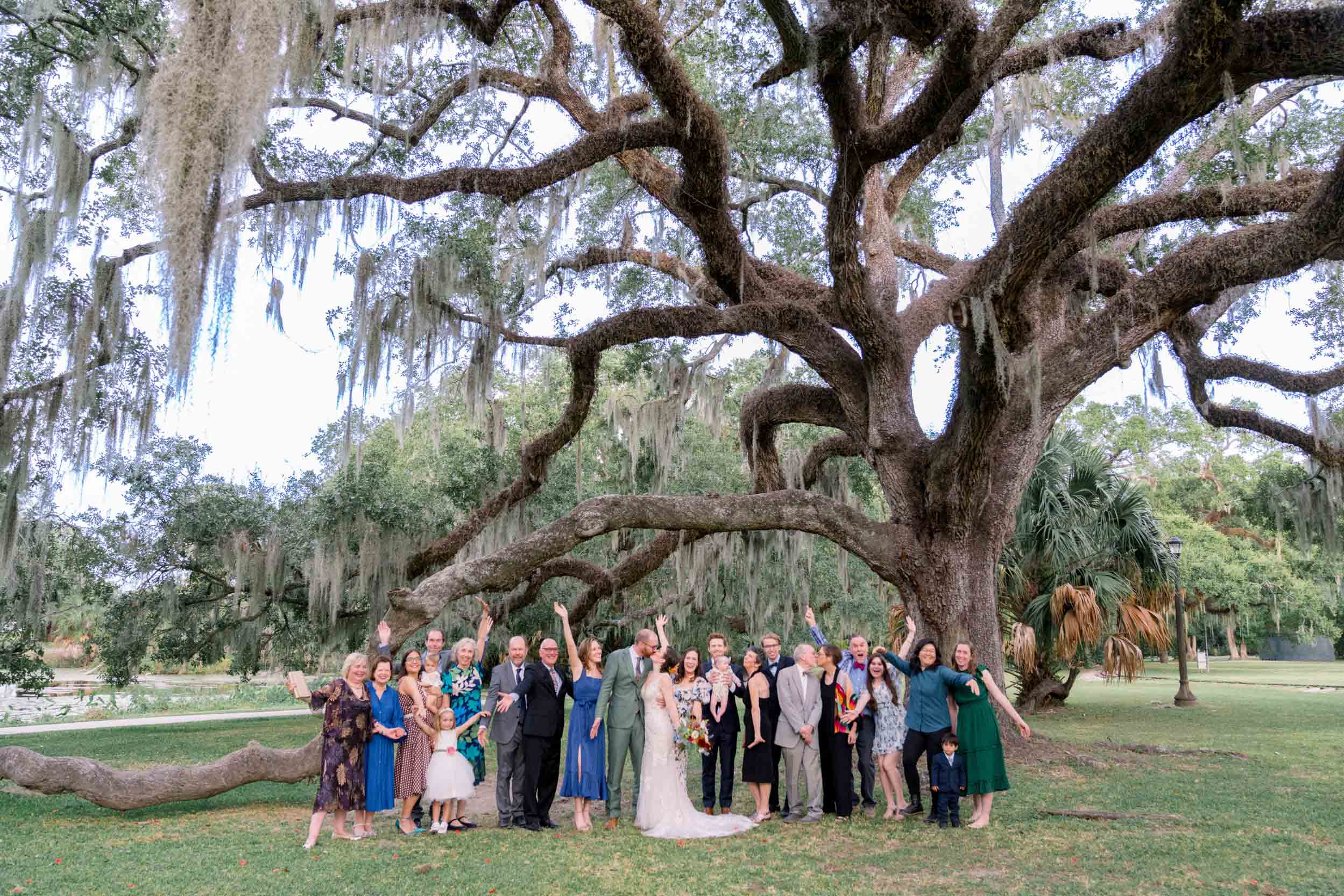 family members standing in front of large oak tree on wedding day at the Botanical Gardens in City Park New Orleans