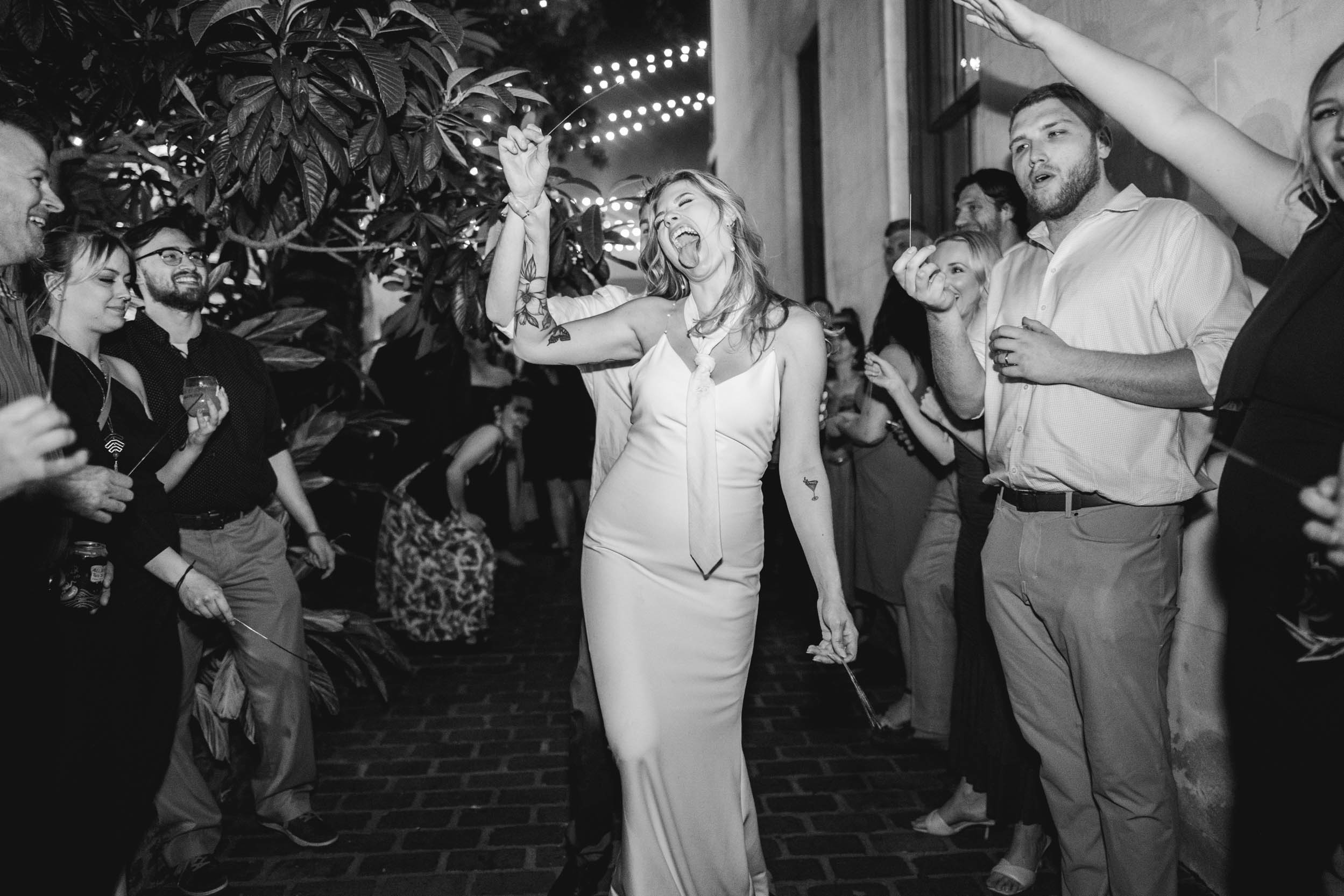 flash photo of bride sticking her tongue out during sparkler exit on wedding day at at Margaret Place in New Orleans