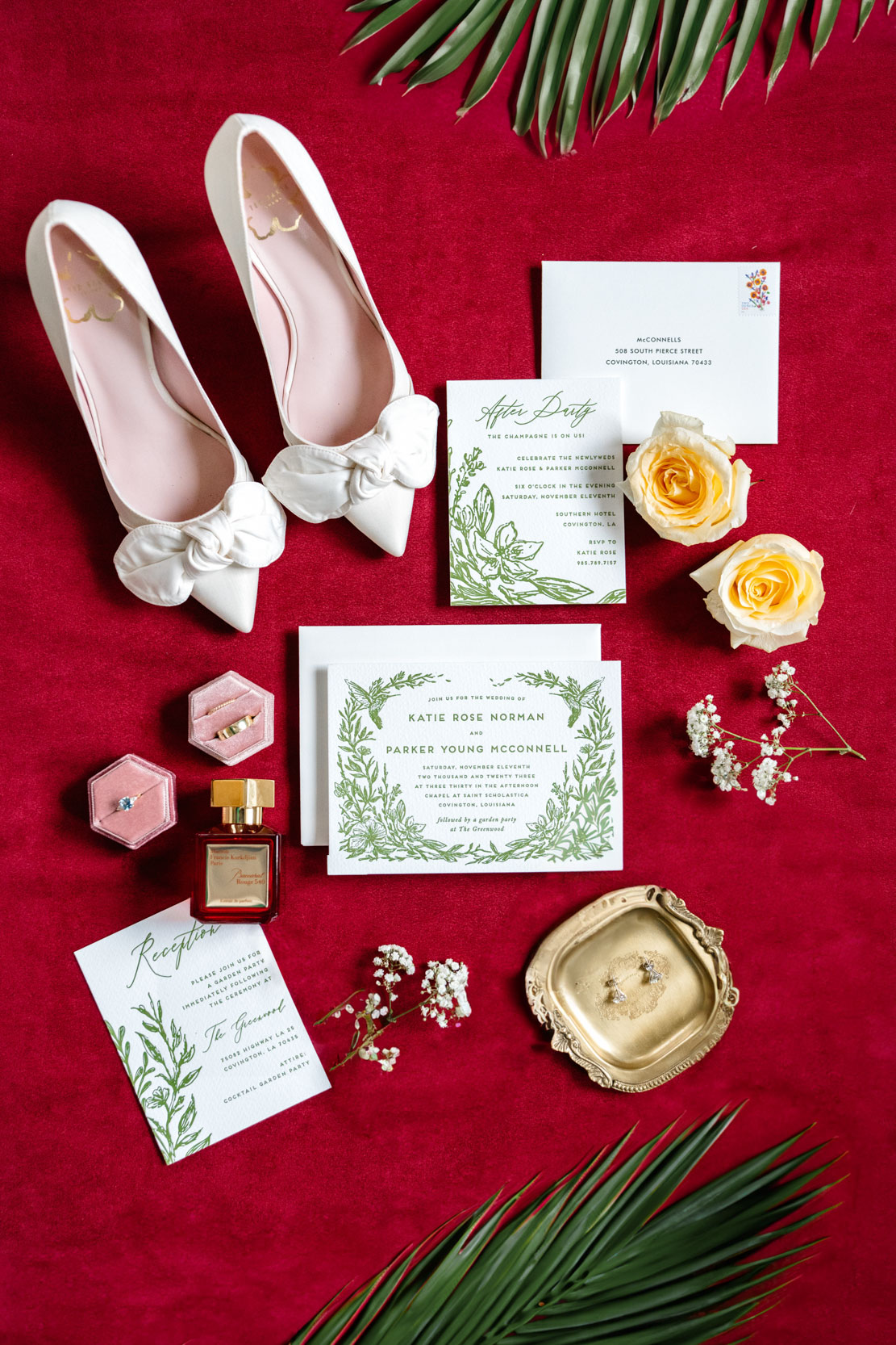 flat lay on red burgundy velvet of bridal shoes, invitations, Ted Baker London shoes, Maison Francis Kurkdjian perfume, and rings from Diamonds Direct at the Southern Hotel in Covington, Louisiana