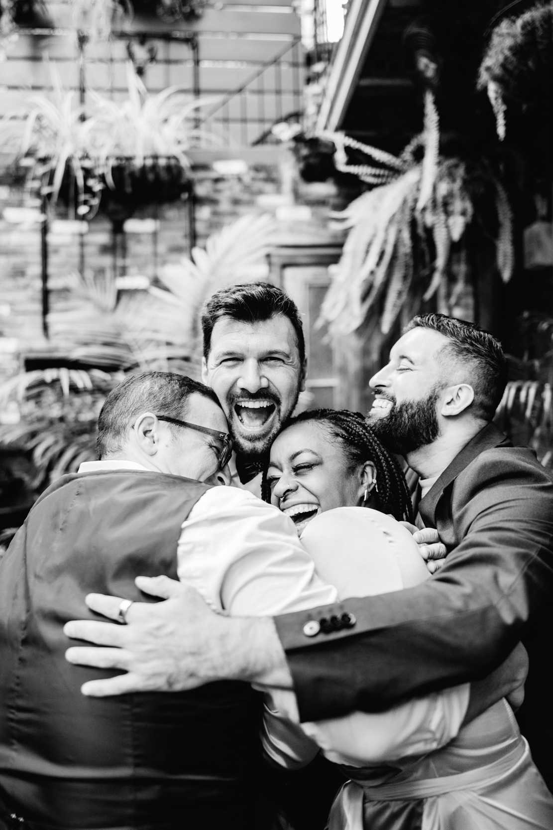 groom laughing and hugging with friends at gay wedding day at the Historic Swoop Duggins House in New Orleans